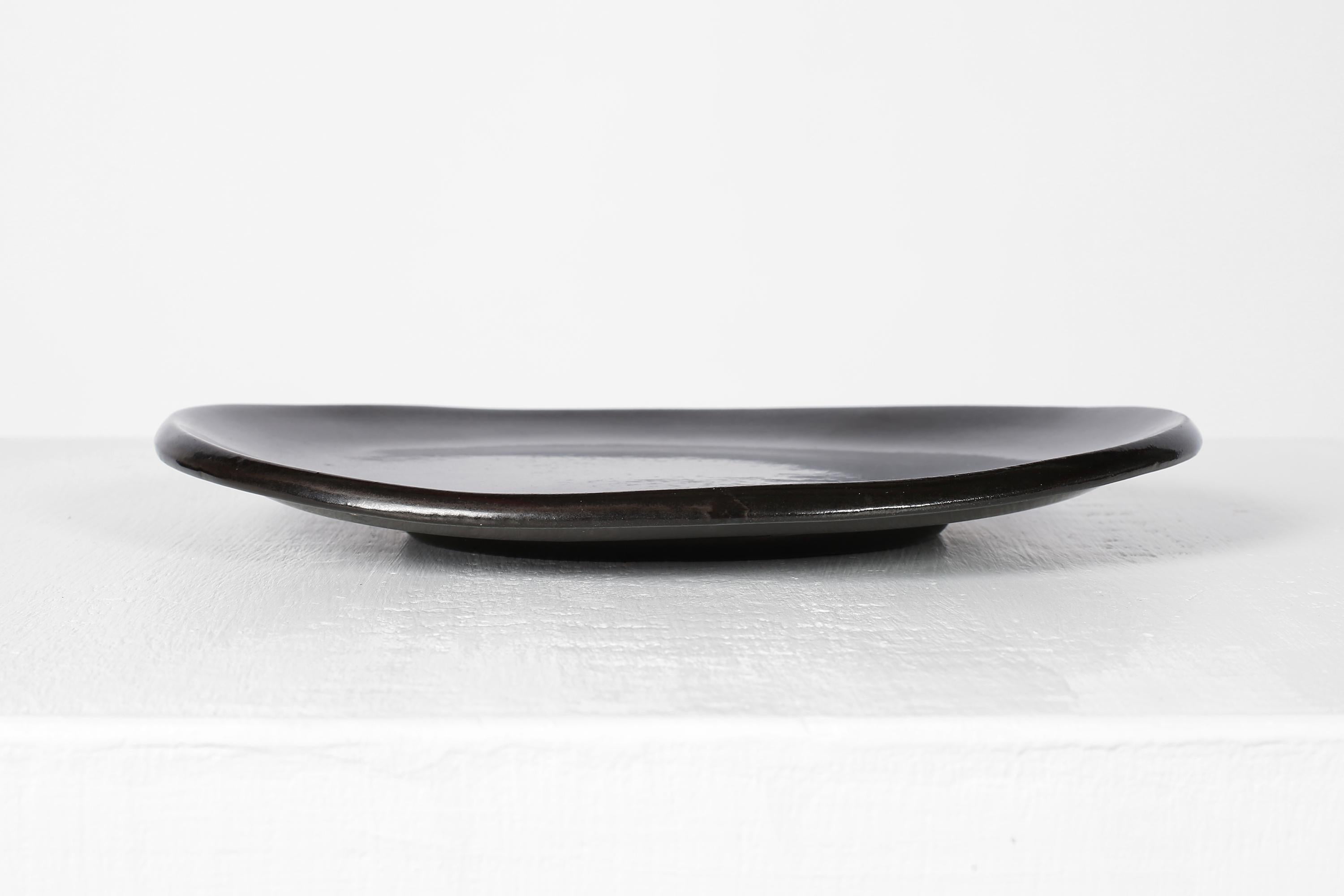 A subtly freeform, black glazed ceramic dish or vide-poche by Suzanne Ramié (1905-1974) for Atelier Madoura, stamped.

French, c. 1960s.

One of the most notable potters to come out of the famous Vallauris commune, Ramié is best known for her