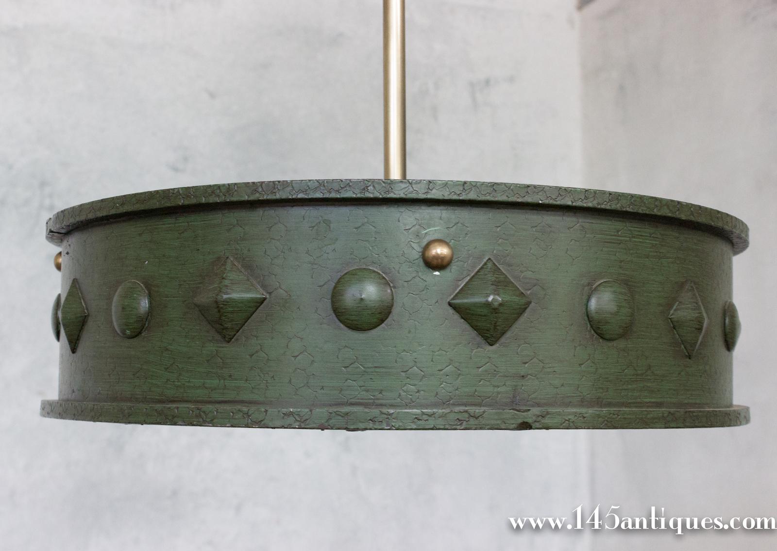 This unique French 1950s hand patinated green metal ceiling fixture features a textured surface and raised decorations, and comes with a matching canopy and suspension rod. The frosted glass diffuses the light beautifully and the fixture has