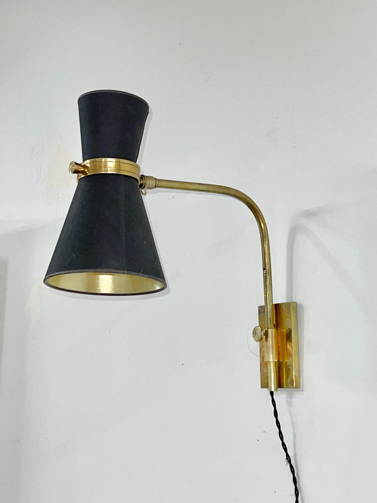 High quality French 1950's wall mounted swing arm lamp by Maison Lunel.
Brass curved arm swings 180 degrees and is height adjustable by adjusting the knob on the stem.
Diabolo double cone light articulates with knurled swivel joint.
Brass box