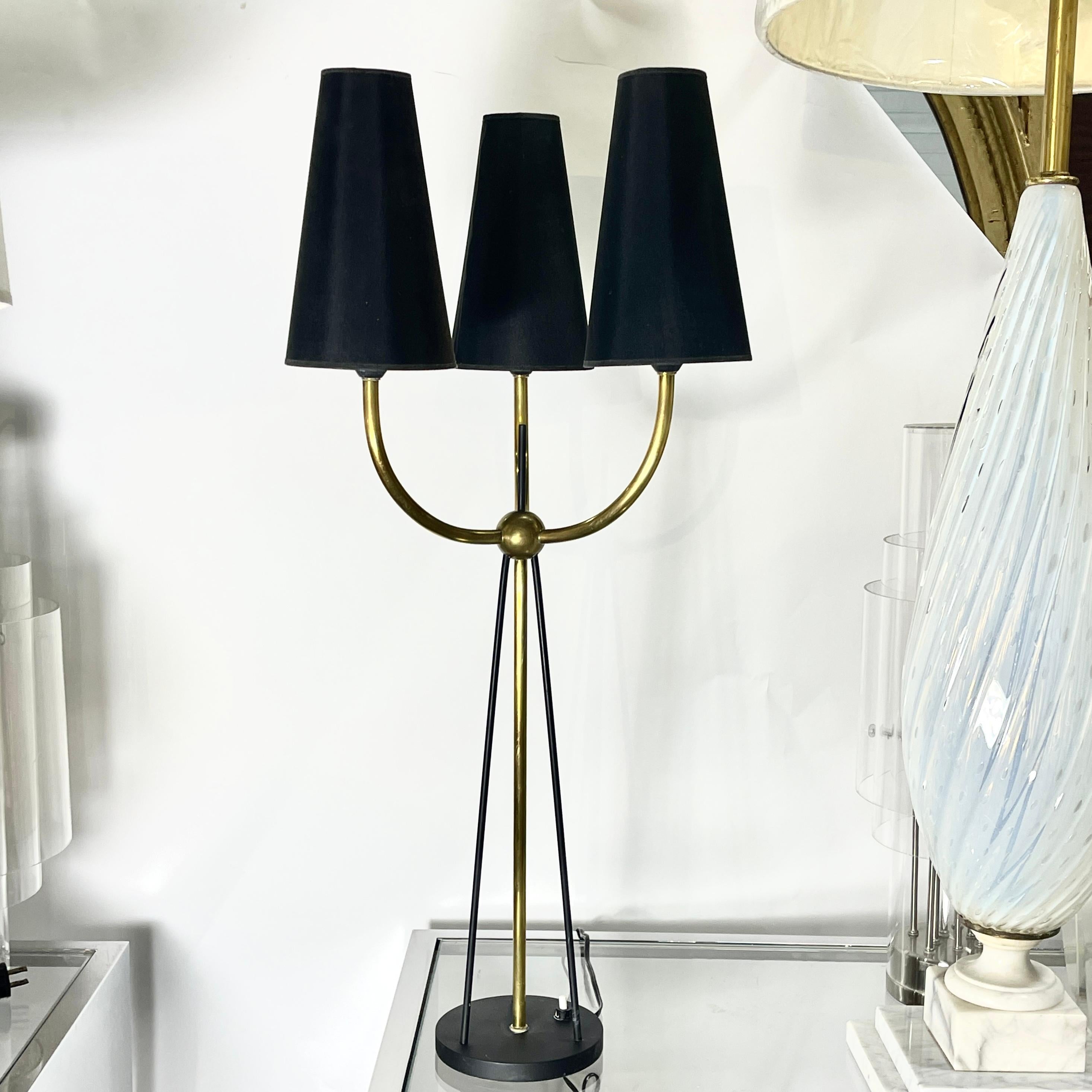 Absolutely charming French 1950's table lamp with three candelabra sockets shown with upward facing yellow paper shades and black tapered 