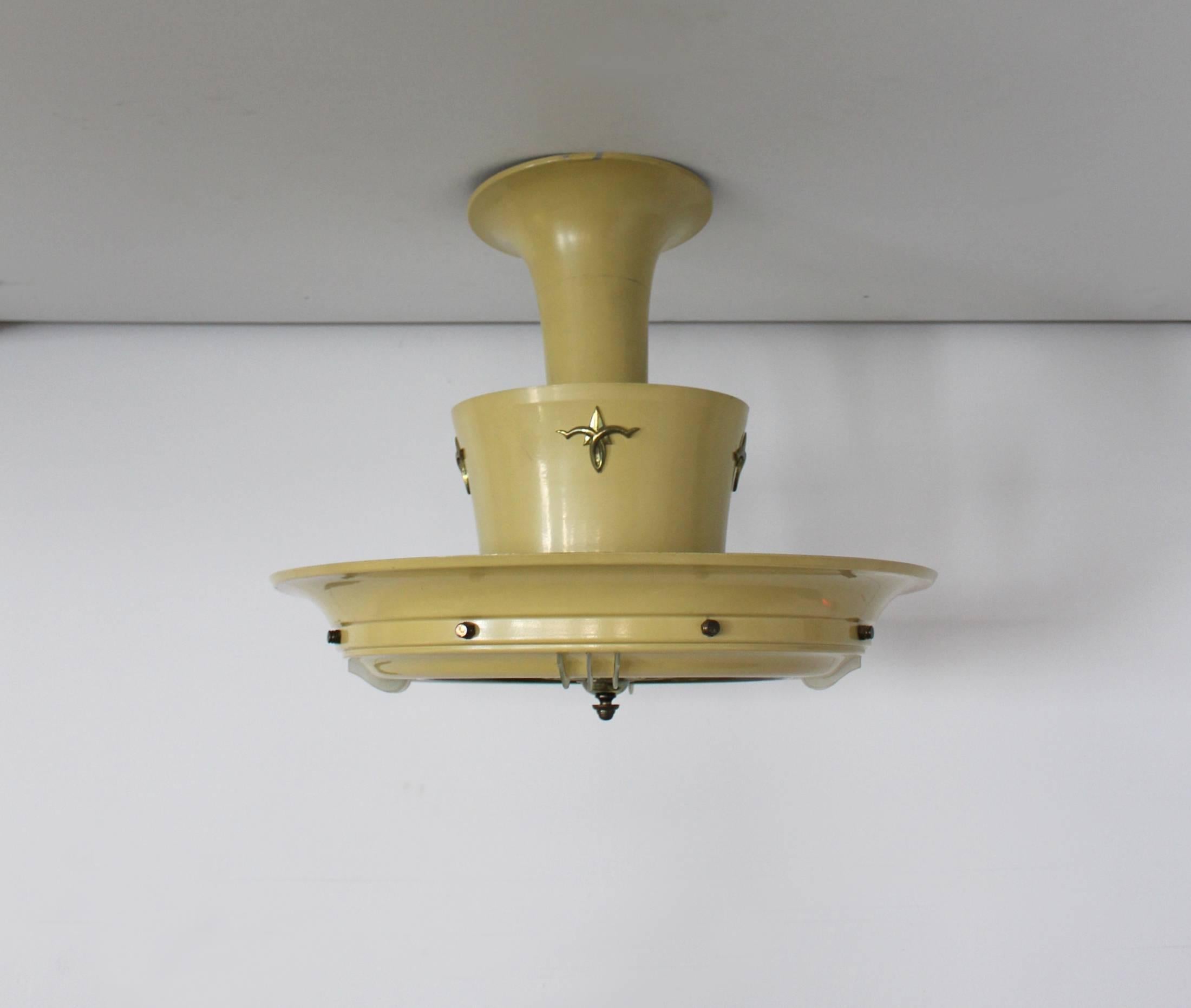 A midcentury round French pale yellow lacquered metal chandelier with a frosted glass diffuser and matching blades decorated with brass details and a center brass rosette.