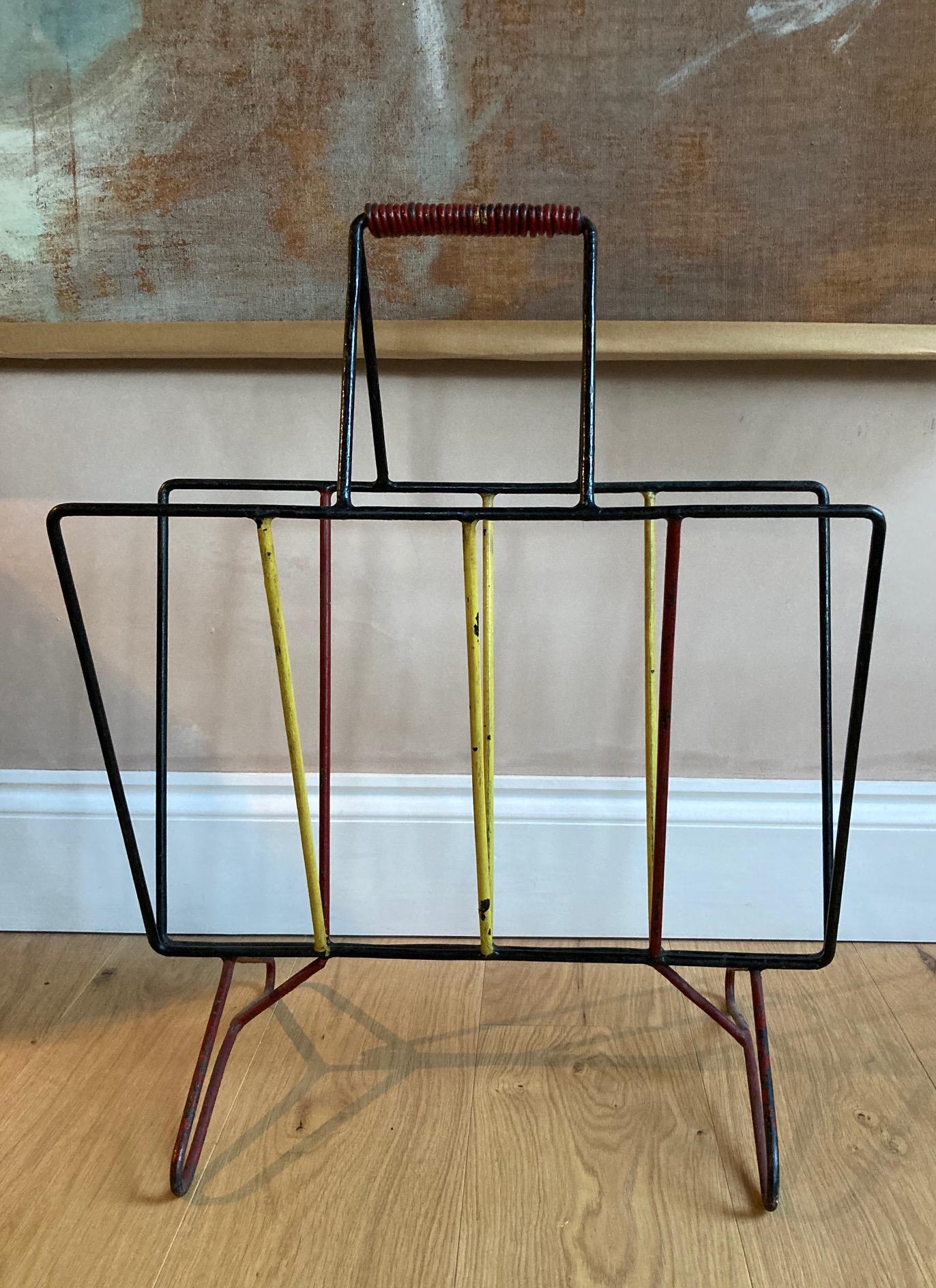 A fabulous large French midcentury painted iron magazine rack in the style of Mathieu Mategot. A period midcentury piece, larger than average magazine racks so able to hold a few magazines, retaining original red, black and yellow paint.