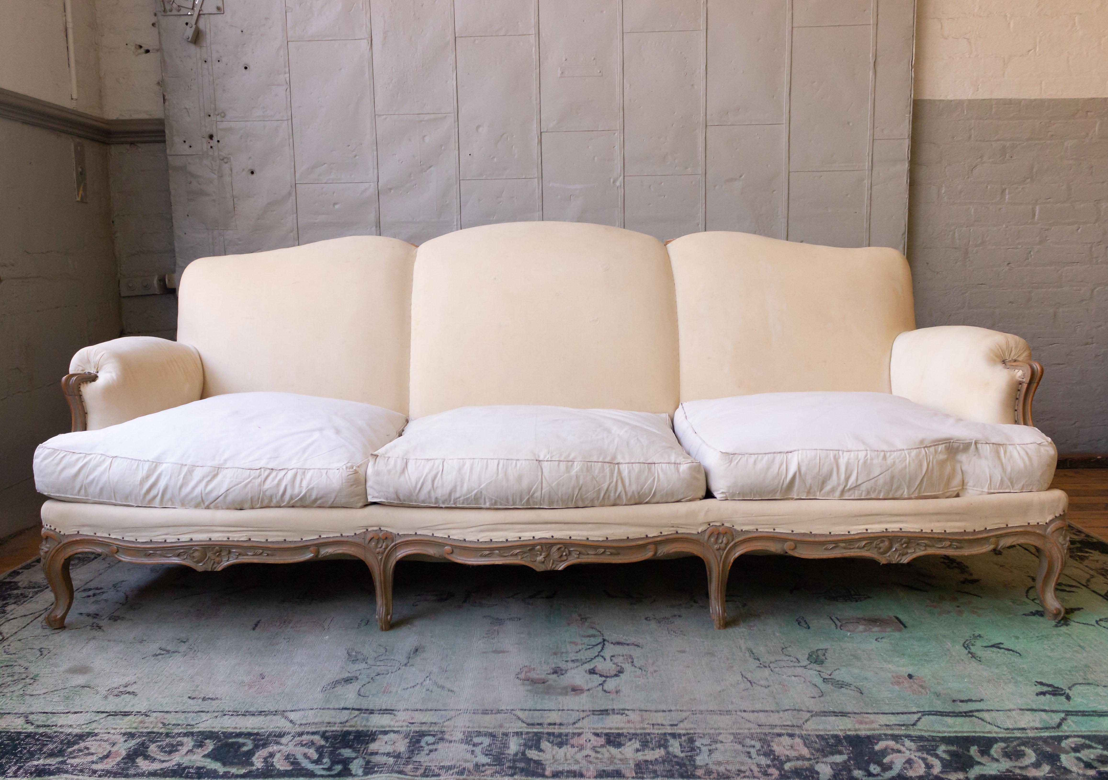 A large French sofa in the Louis VX style, most likely from the 1950s. The sofa has 3 loose seat cushions and a tight back, and is ready to be upholstered. Sold as is.
