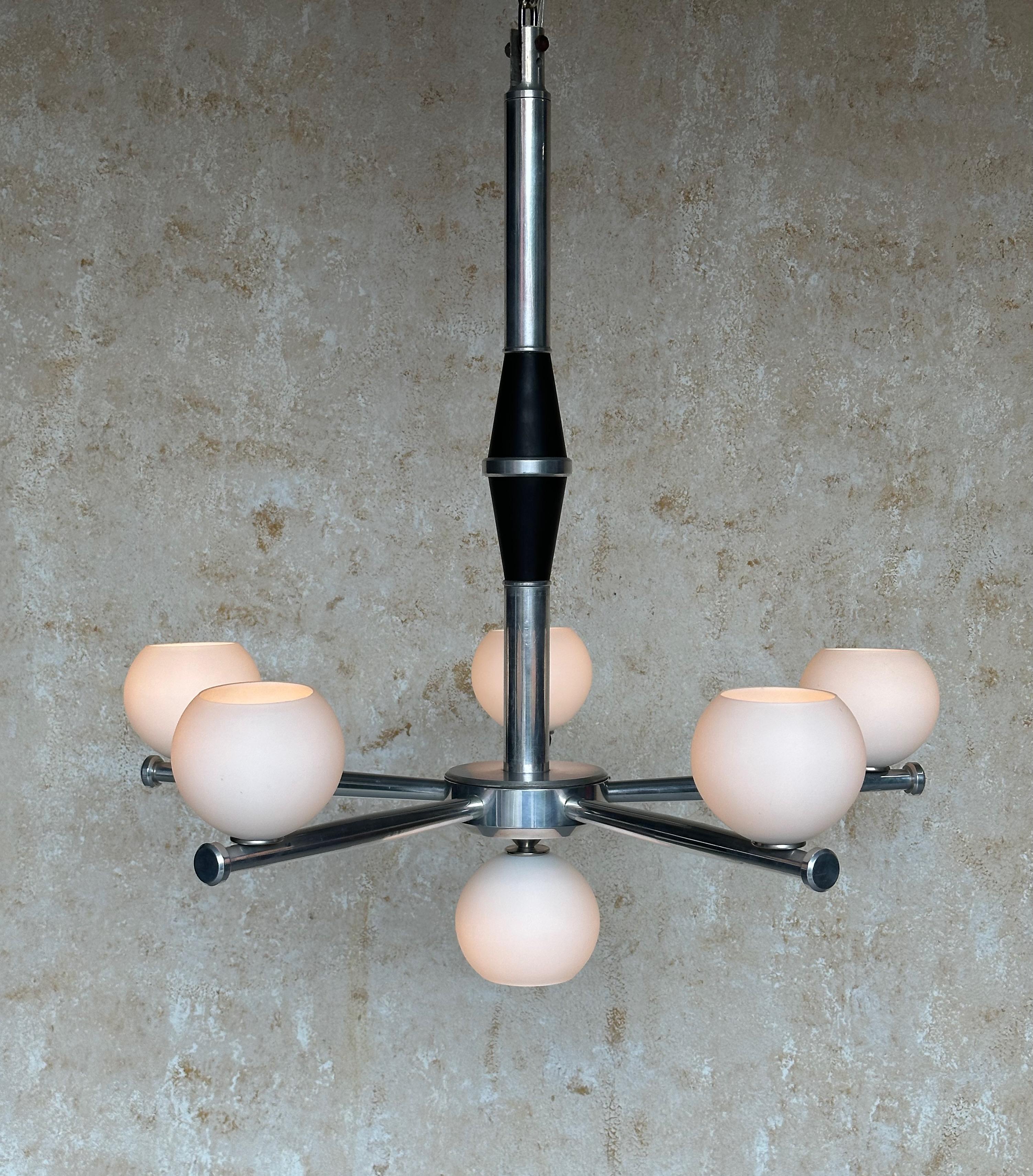 Questo notevole lampadario francese in alluminio fuso della metà del secolo scorso presenta sei globi di vetro smerigliato. Questo splendido pezzo è in ottime condizioni vintage ed è stato recentemente ricablato, garantendo funzionalità e sicurezza.