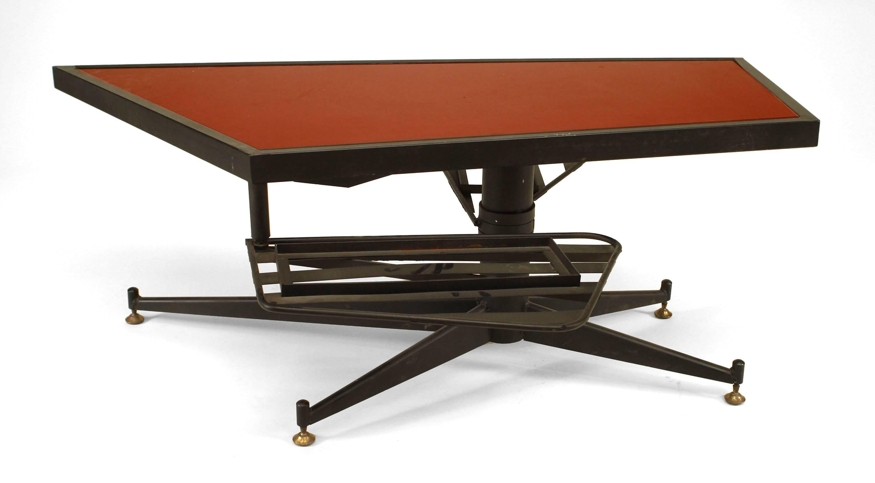 French Mid-Century Modern (1950s) ebonized metal coffee table with an irregularly-shaped top with inset red glass and a pedestal base with two swivel shelves.
