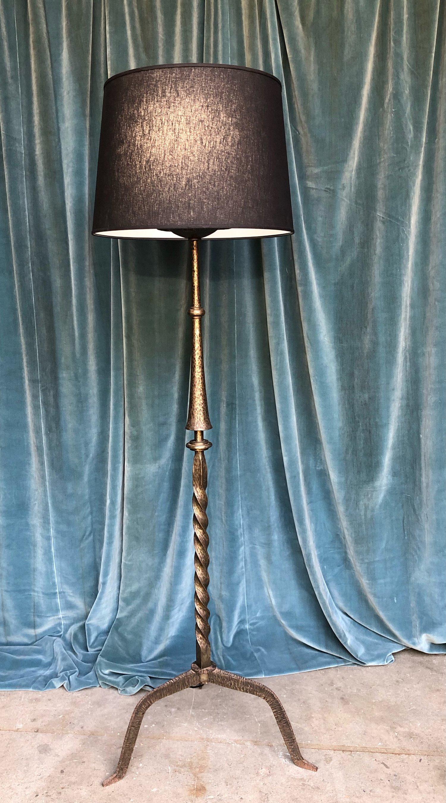 Diese atemberaubende Stehleuchte aus Eisen der französischen Moderne aus den 1950er Jahren ist ein wahres Meisterwerk des Designs der Jahrhundertmitte, das Stil, Funktionalität und Langlebigkeit vereint. Diese bezaubernde Lampe ist ein absolutes