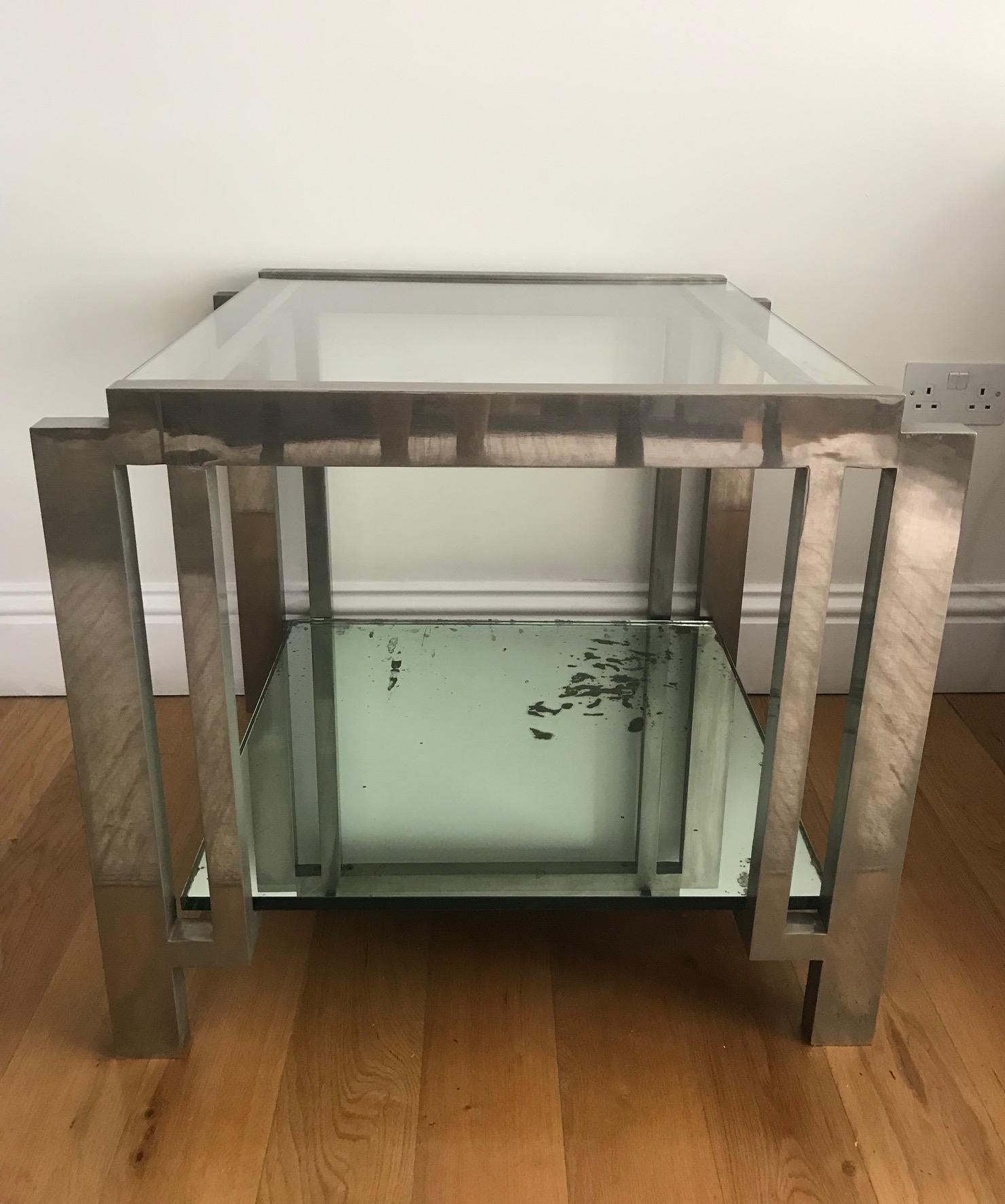 Fabulous French 1950s Nickel and glass side table in the style of Jacques Adnet. Of excellent quality and design. Some damage to the mirrored bottom shelf. (Chip off corner and foxing).