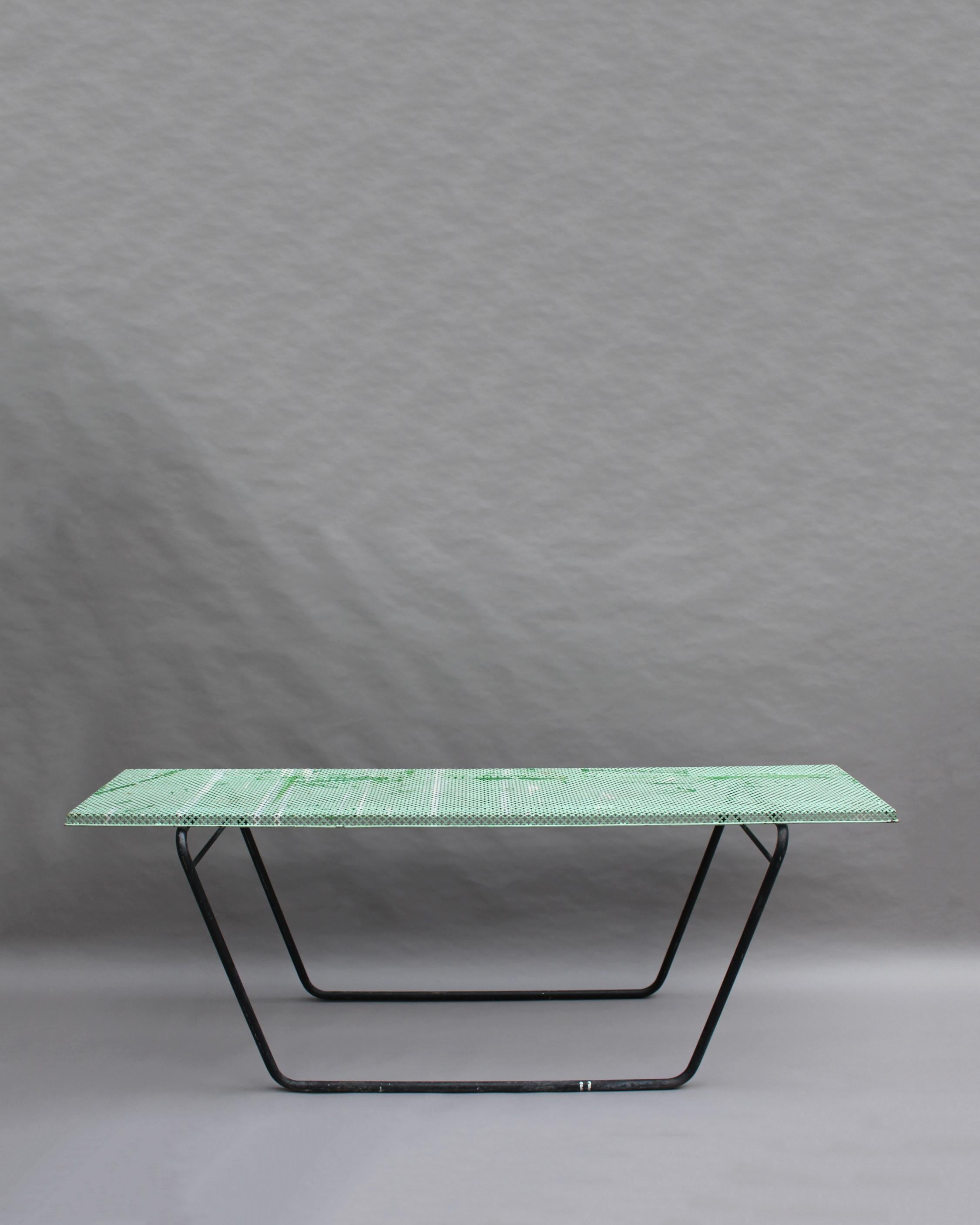 A French midcentury perforated metal console in the style of Mathieu Matégot with a tubular metal base.
 