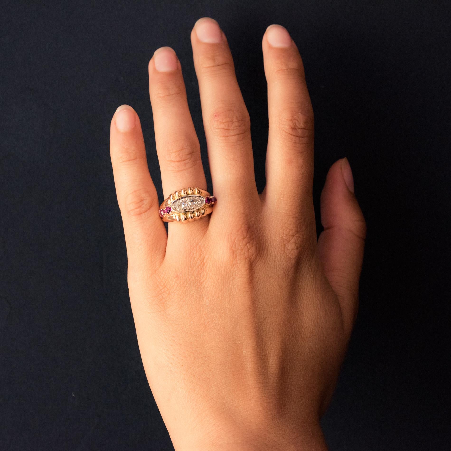 Ring in 18 karat rose gold, eagle's head hallmark.
Astonishing antique ring, it is formed by a bangle set, on the top, with a shuttle motif retaining 4 rose- cut diamonds within a gadrooned motif. On both sides are set 2x2 rubies.
Height: 12.9 mm,