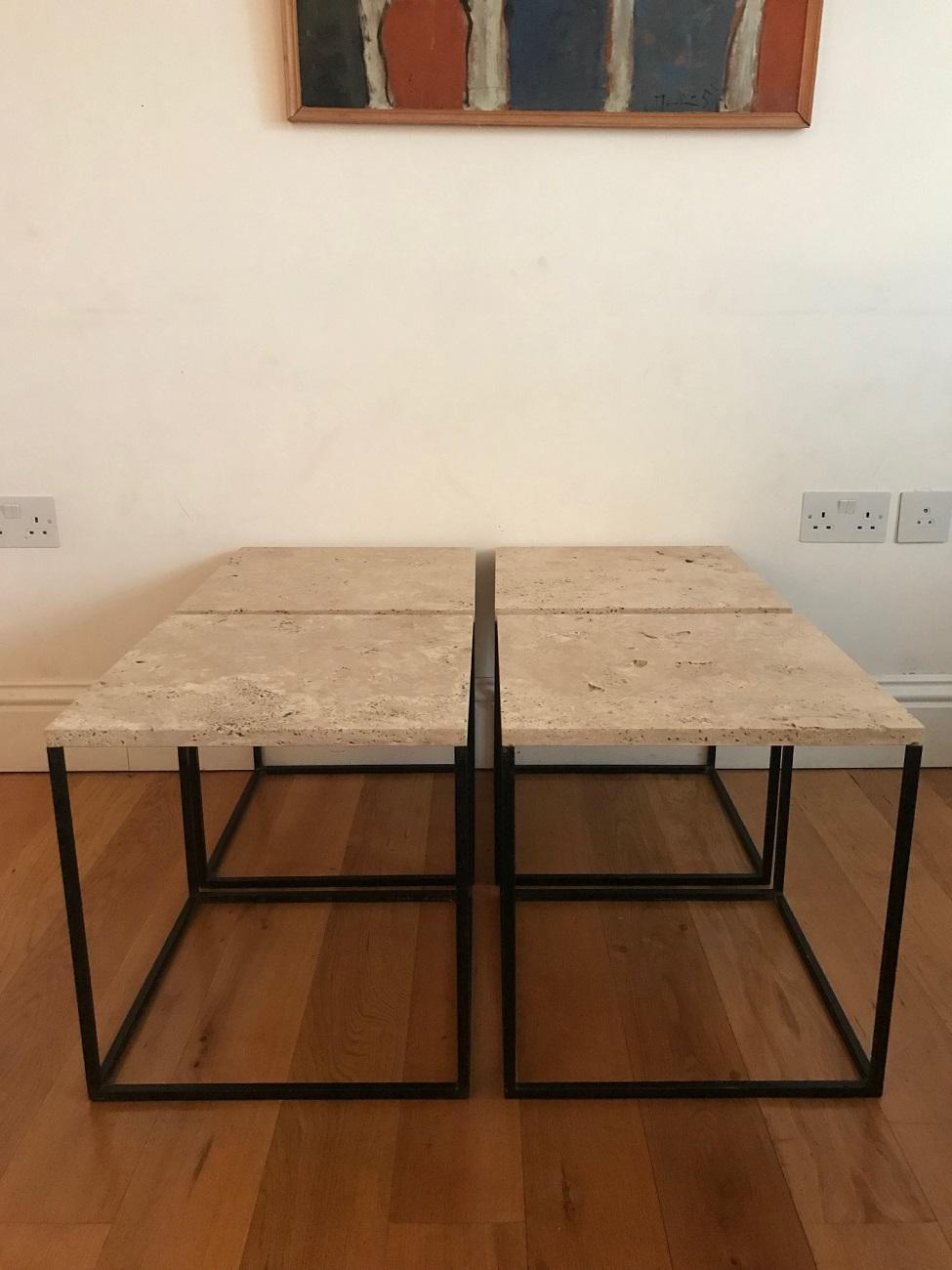 A set of four small black metal and unfilled travertine stone topped side tables, which can be separated or made into one coffee table. French, circa 1950s. The unfilled travertine tops are irregular and have fabulous natural warm feel to them and