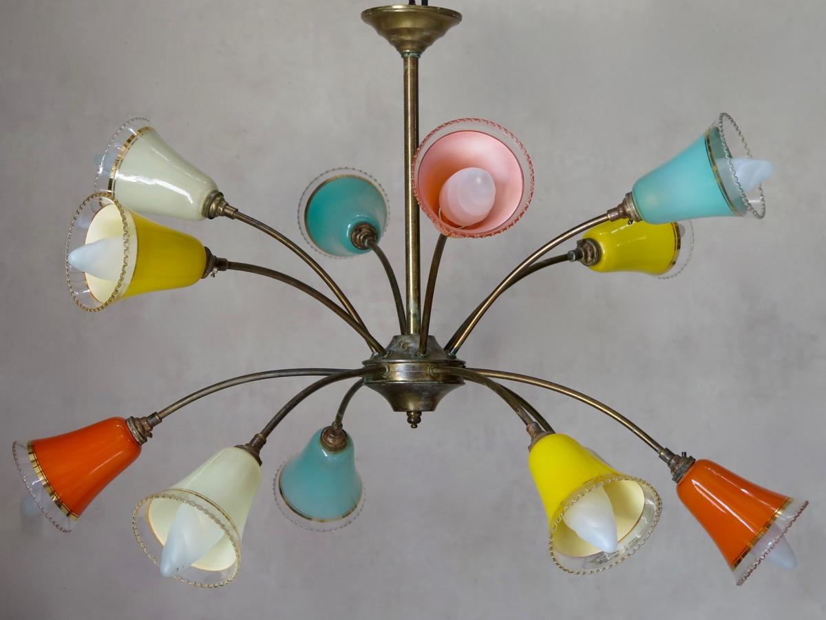 Colorful and lovely brass chandelier with twelve glass shades, painted on the interior. The shades have frilled edges, and gold-colored detailing.