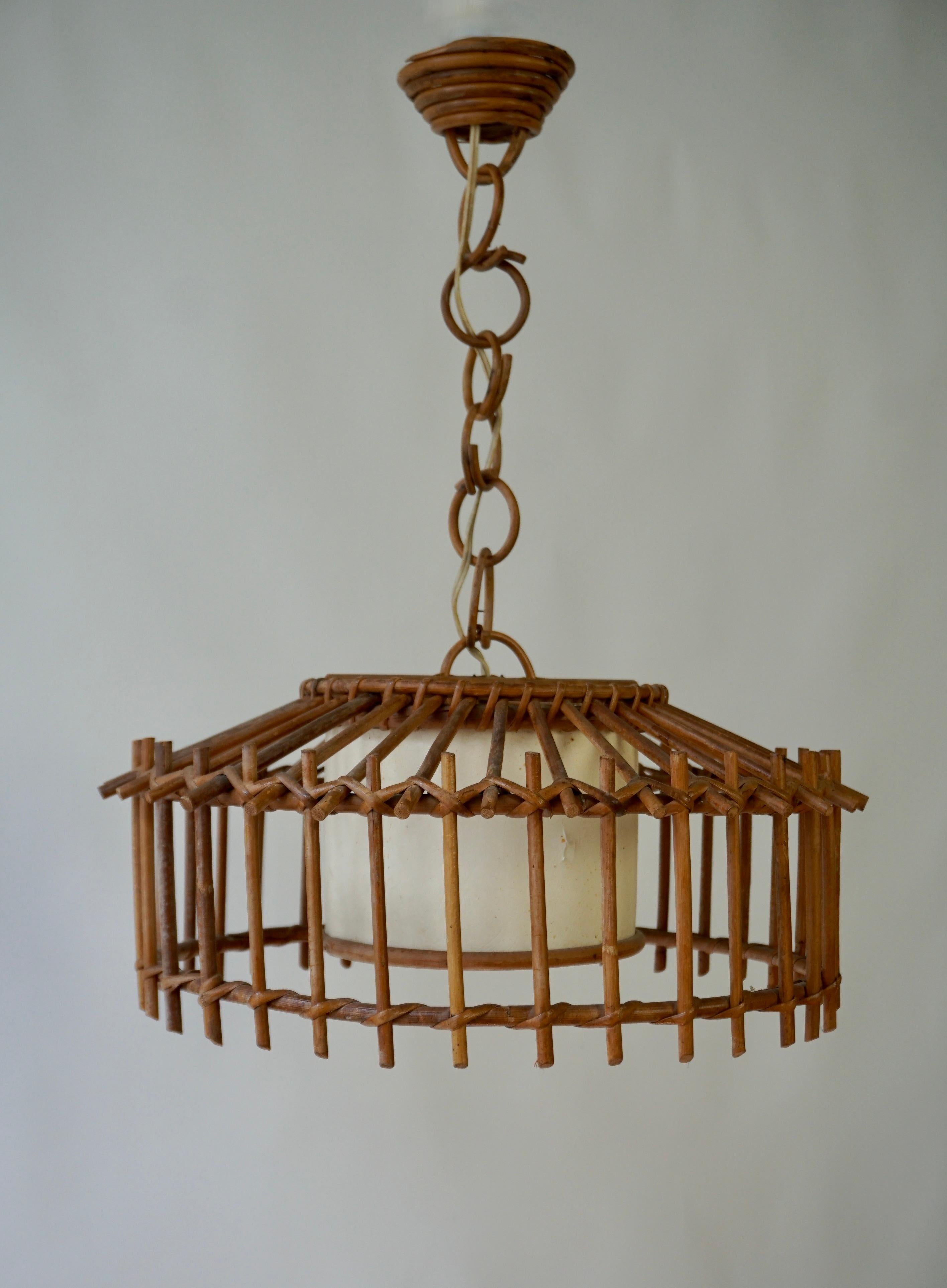 Bamboo and rattan french pendant lamp. Mid-century round piece with an interior parchment paper shade with a sort of linen texture. The interior shade is surrounded by a separate, round, rattan encasement.


Diameter 15.7