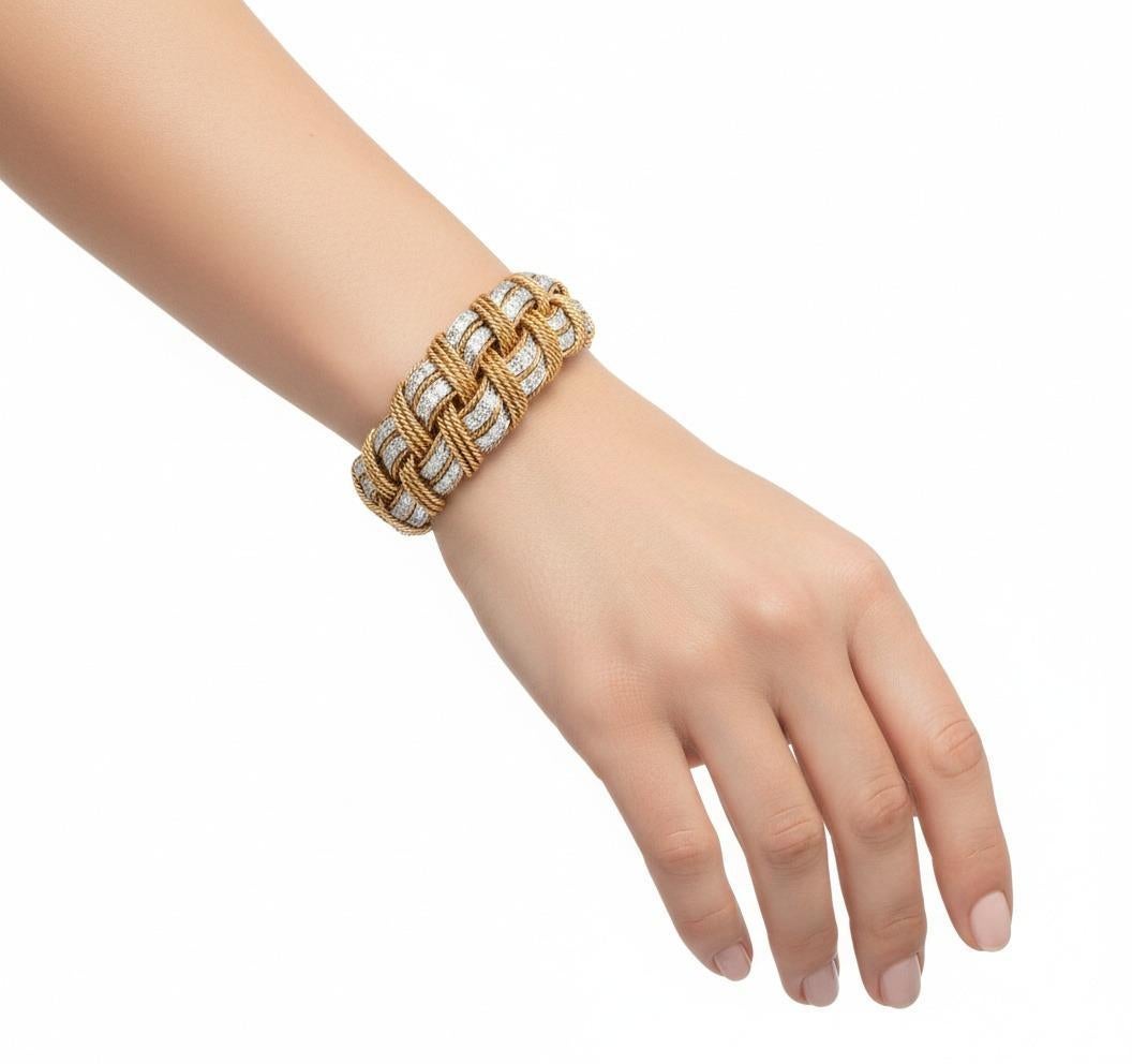 Ce spectaculaire bracelet en corde met en valeur le savoir-faire exquis de l'art joaillier français des années 1960, réalisé avec expertise en or jaune massif 18kt et en platine et rehaussé de 68 diamants calibrés de taille ronde totalisant 5,04