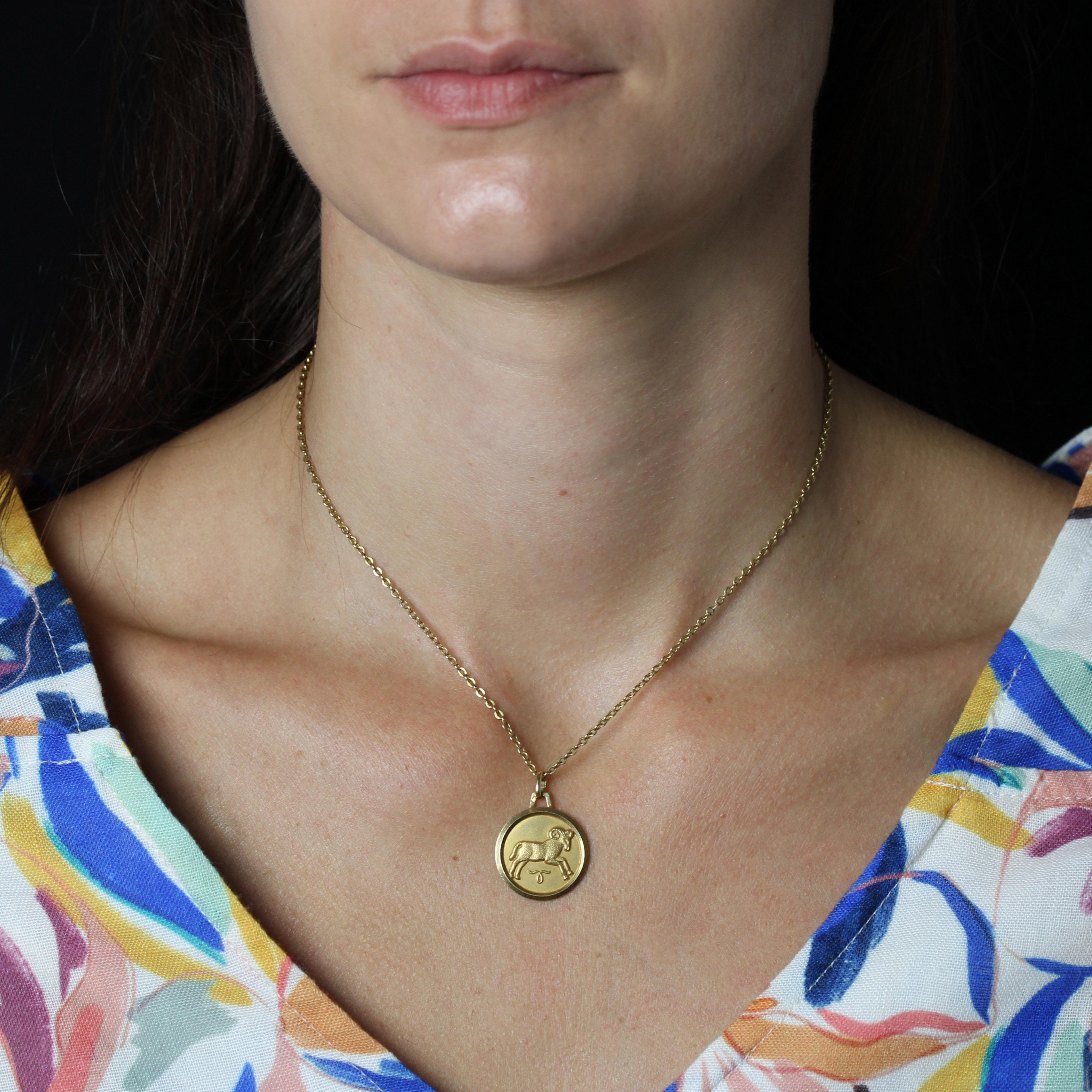 Ciondolo in oro rosa 18 carati, marchio di fabbrica con testa d'aquila.
Medaglia rotonda su sfondo amati, raffigurante il segno zodiacale dell'Ariete accompagnato dal suo simbolo, con bordo e retro lisci.
Il ciondolo è venduto solo, senza la catena