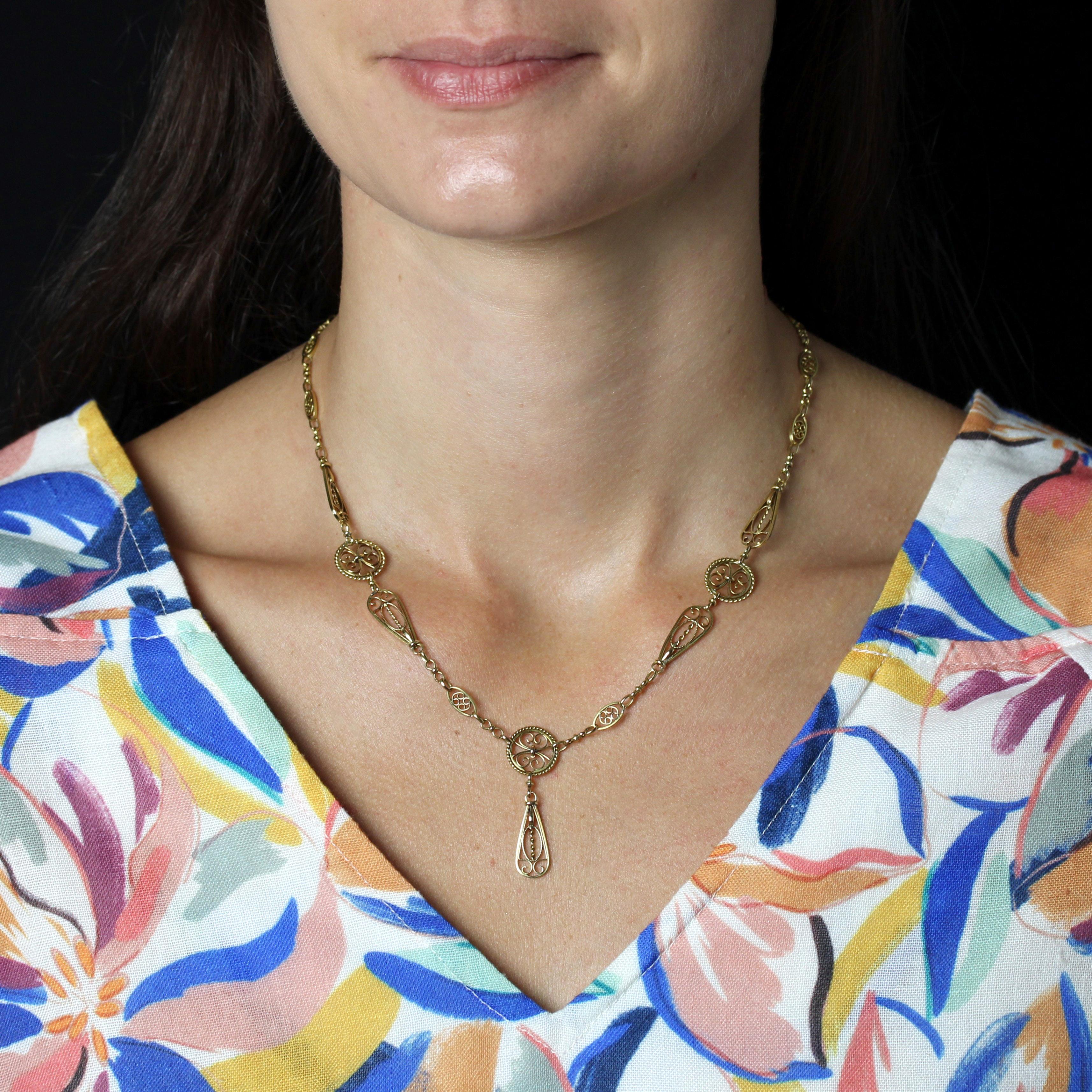 Collana in oro giallo 18 carati, con marchio dell'aquila e della testa di rinoceronte.
Questa collana femminile in oro vintage è composta da un'alternanza di motivi ovali, a goccia e rotondi, decorati con trafori e filigrana. Questi motivi sono
