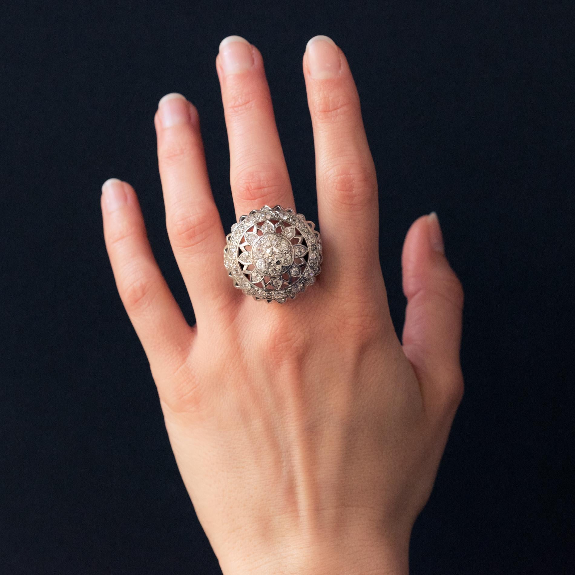 Ring in 18 karat white gold, owl hallmark.
Superb ball ring, it is composed in its center of an openwork sun motif set with diamonds. The mounting is surrounded by a row of diamonds. The entire border is serrated and punctually set with diamonds.