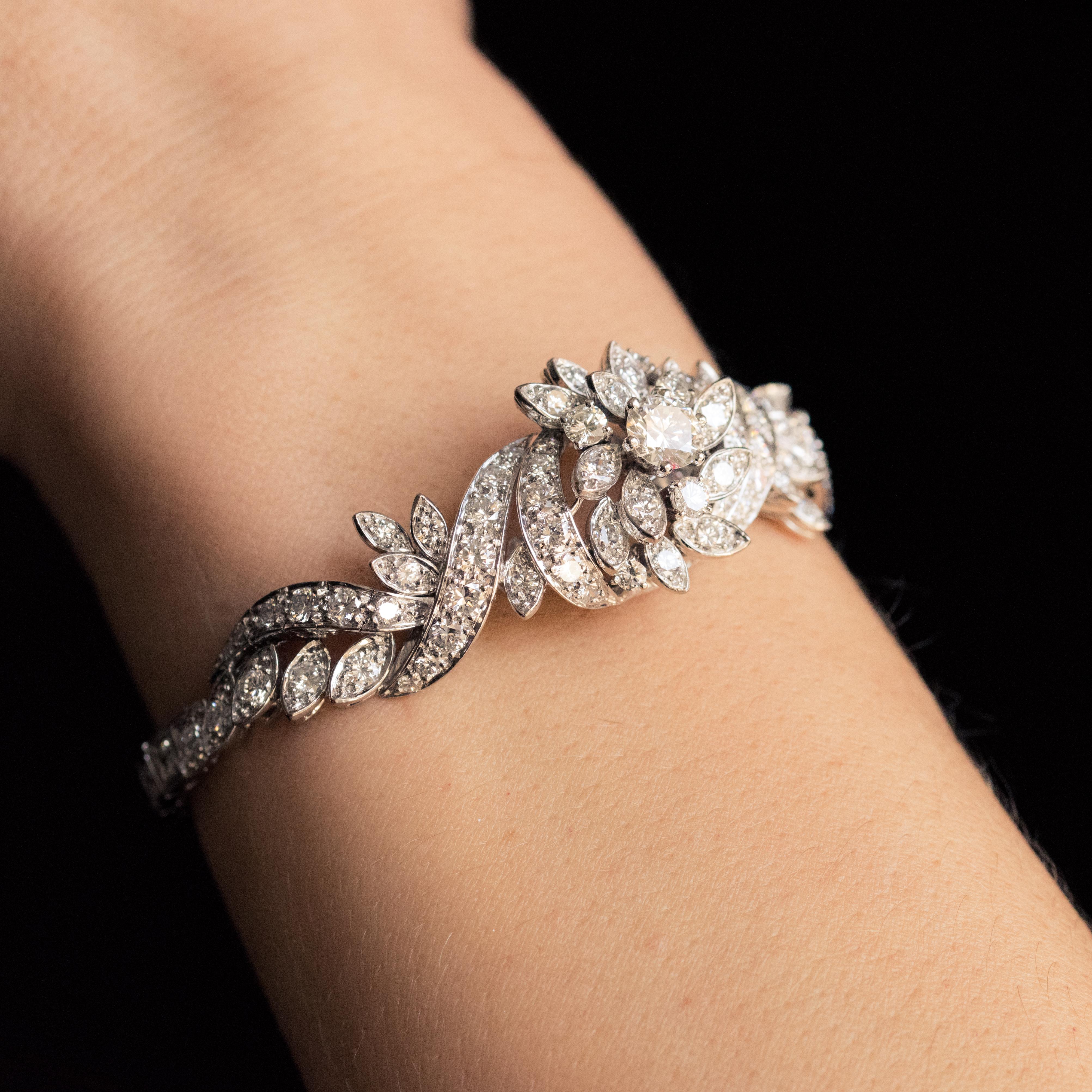 Bracelet in 18 karat white gold.
Sublime piece of retro jewelry, this antique bracelet forms on the top an openwork bouquet with flower, leaves and ribbons all adorned with brilliant-cut diamonds. On either side, the rest of the bracelet is a line