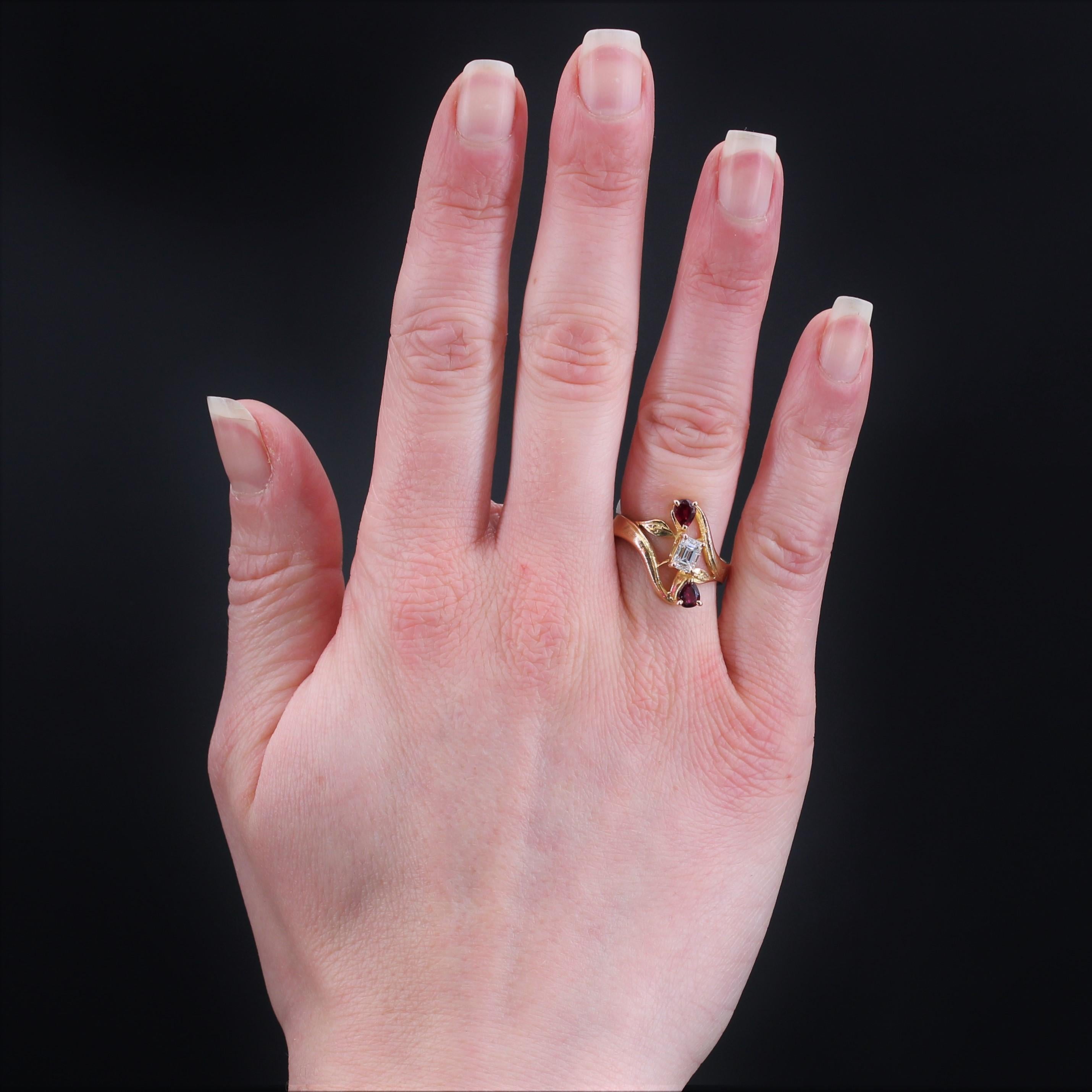 Ring aus 18 Karat Gelbgold, Adlerkopfpunze.
Originaler antiker Ring, der auf der Fassung mit einem Diamanten im Baguetteschliff in der Mitte und 2 Rubinen im Birnenschliff auf beiden Seiten verziert ist. Die Platte ist bewegt, durchbrochen und mit