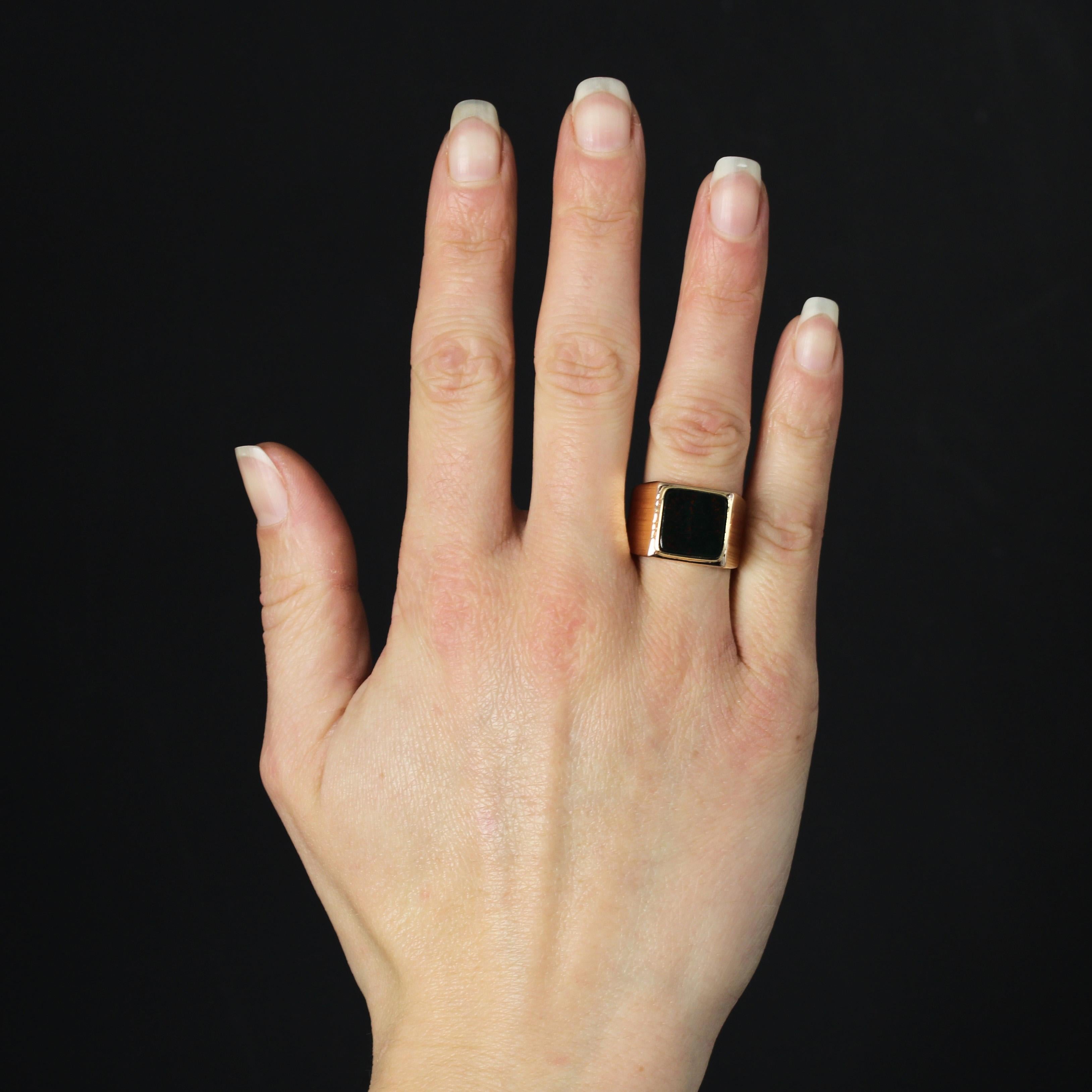 Ring aus 18 Karat Gelbgold, Adlerkopfpunze.
Dieser elegante Siegelring im Vintage-Stil ist mit einer Blutjaspis-Plakette auf der Oberseite besetzt. Beide Seiten des Rings haben eine breite, hängende Öffnung, die mit Rillen verziert ist.
Höhe: ca.