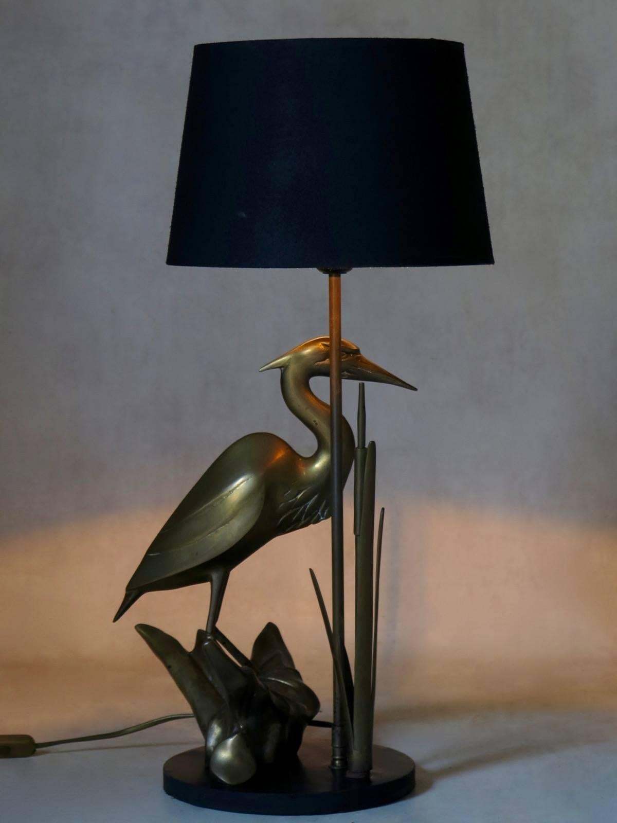 Brass table lamp representing a heron amongst bullrushes. Set on a black-painted round wooden base.