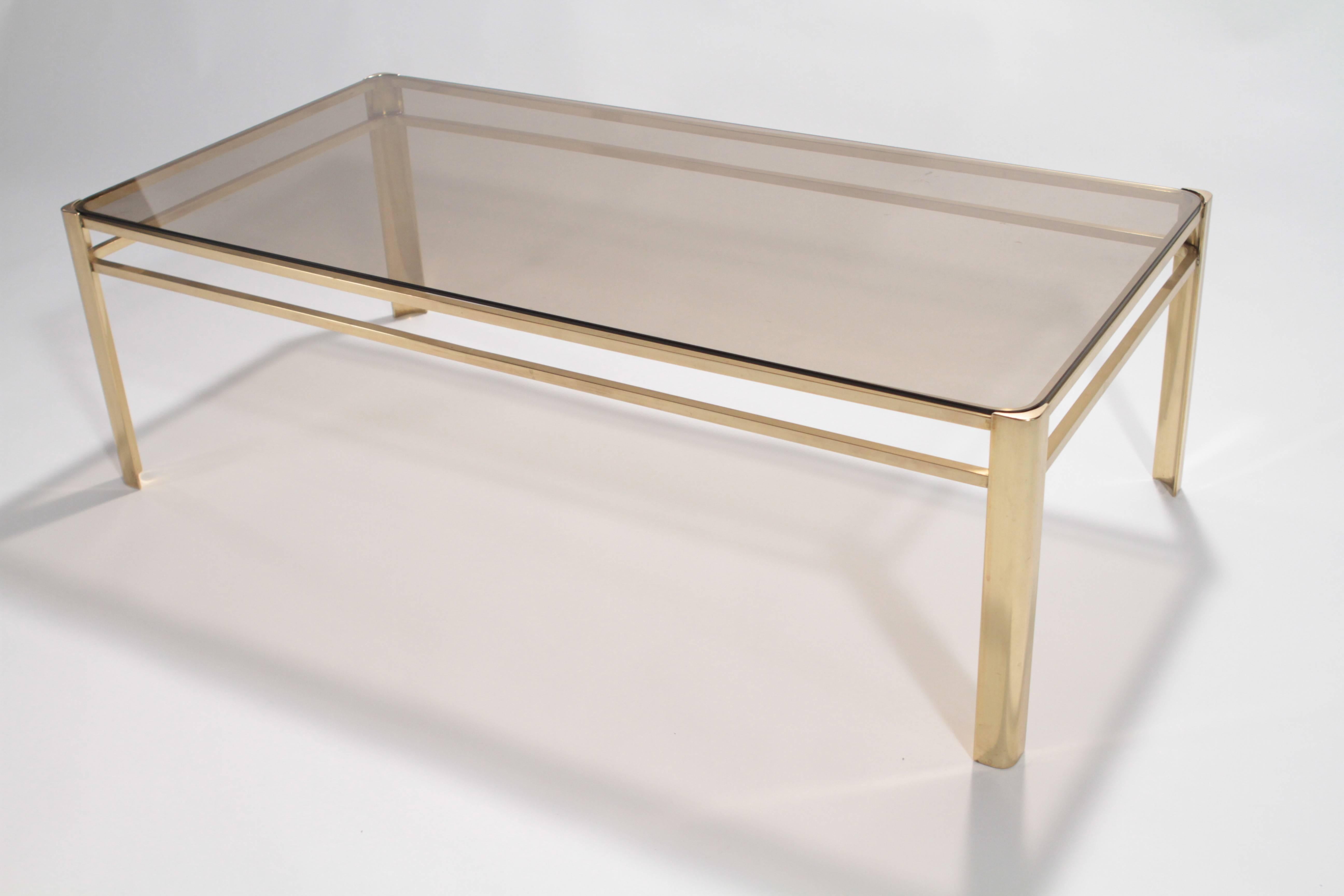 A polished bronze and smoked smoked glass coffee table by Jacques Quinet (1918-1992) for Maison Malabert. Signed and inscribed Broncz TR/387.