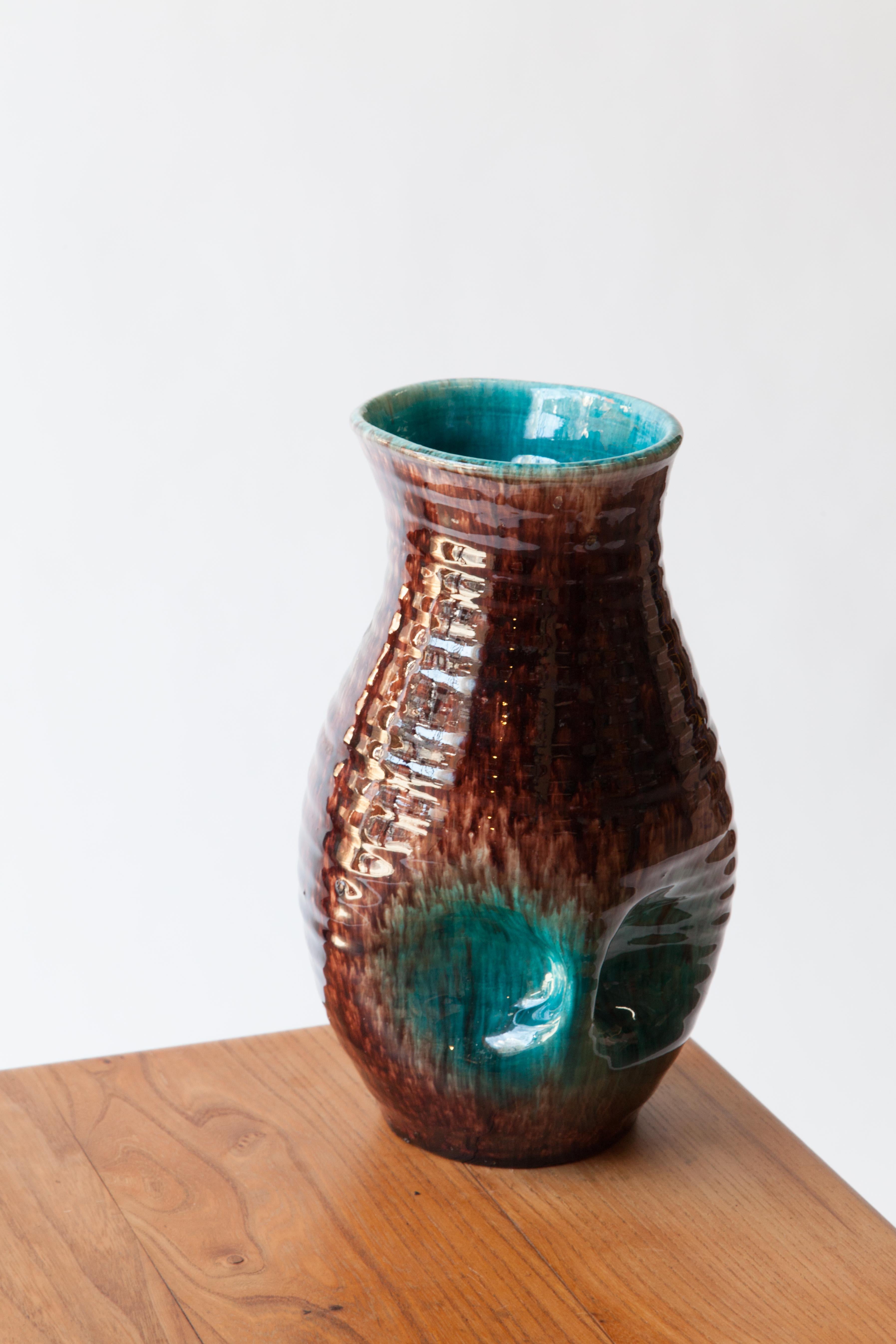 A high gloss glazed ceramic vase. Hand tossed ripples and dimples with a vibrant underlying blue-green glaze, France, 1960s. 

Signed but unknown.
 