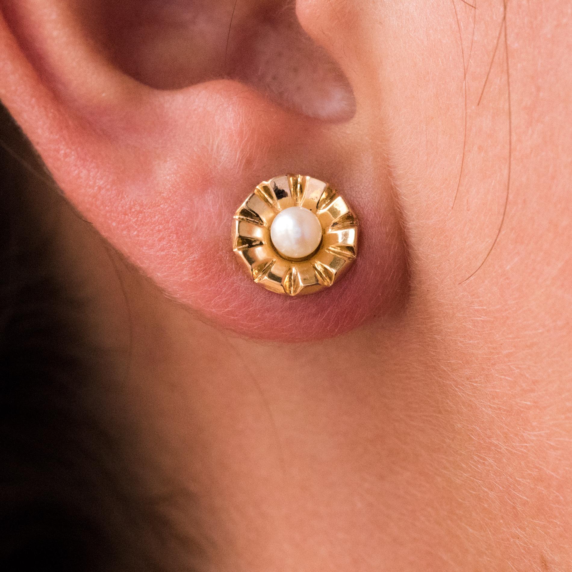 For pierced ears.
Earrings in 18 karat yellow gold, eagle's head hallmark.
Lovely retro earrings, they are made of a chiseled round corolla whose heart is set with a round white orient cultured pearl. The clasp is screw.
Diameter of the pearls : 3.5