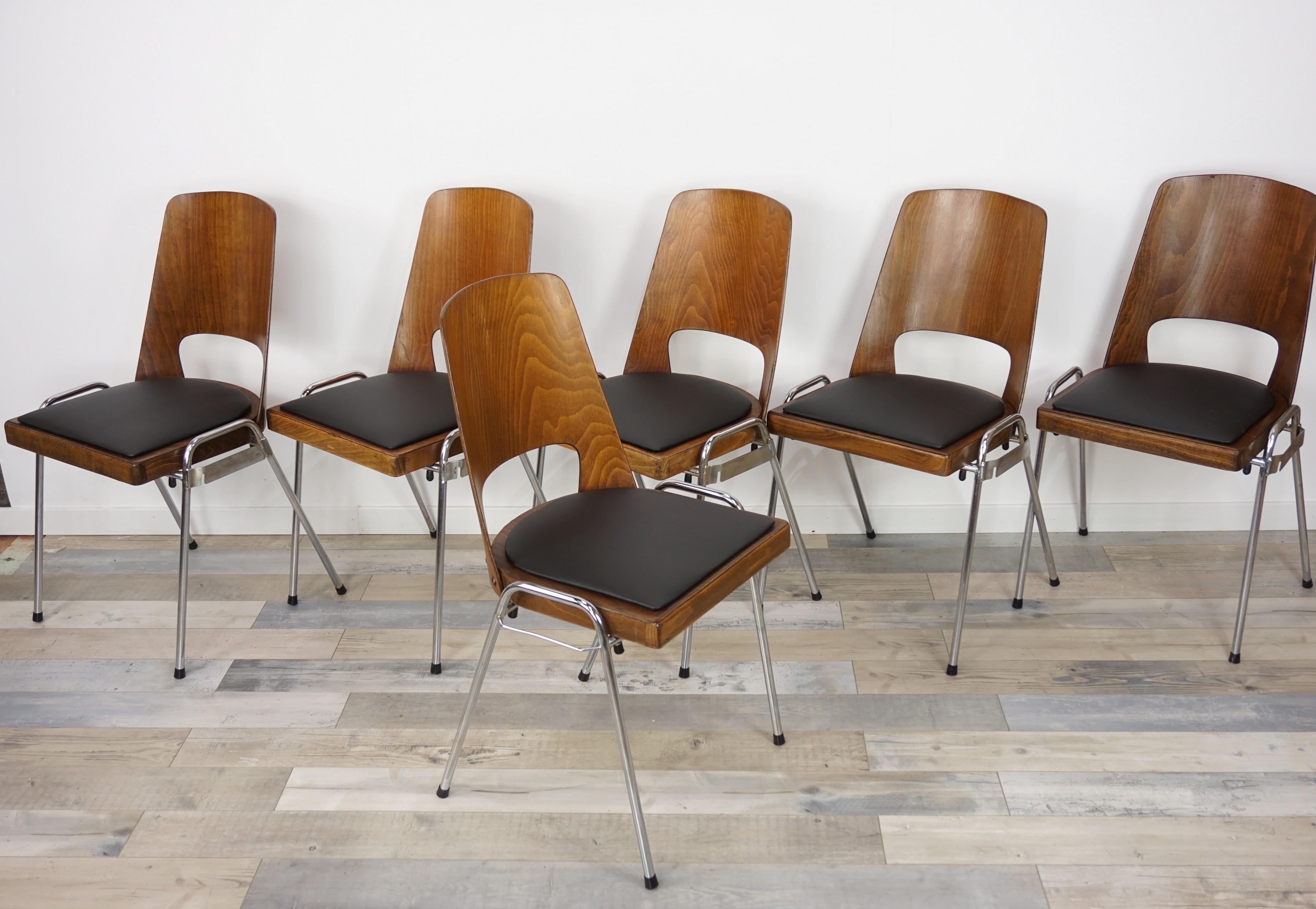 Set of six chairs, industrial and retro look French design by Baumann Edition from the 1960s, composed of a chrome base feet, a plywood shell wearing a comfy black faux leather seat.