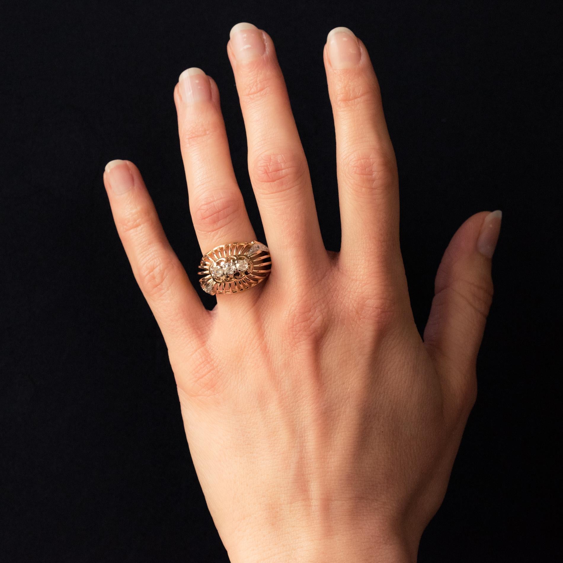Bague en or jaune 18 carats, poinçon tête d'aigle, et en platine, poinçon tête de chien.
Conformément à son époque, cette bague rétro est constituée d'un montage de fils d'or qui forment un dôme, surmonté de 3 diamants, sur platine. Des deux côtés,