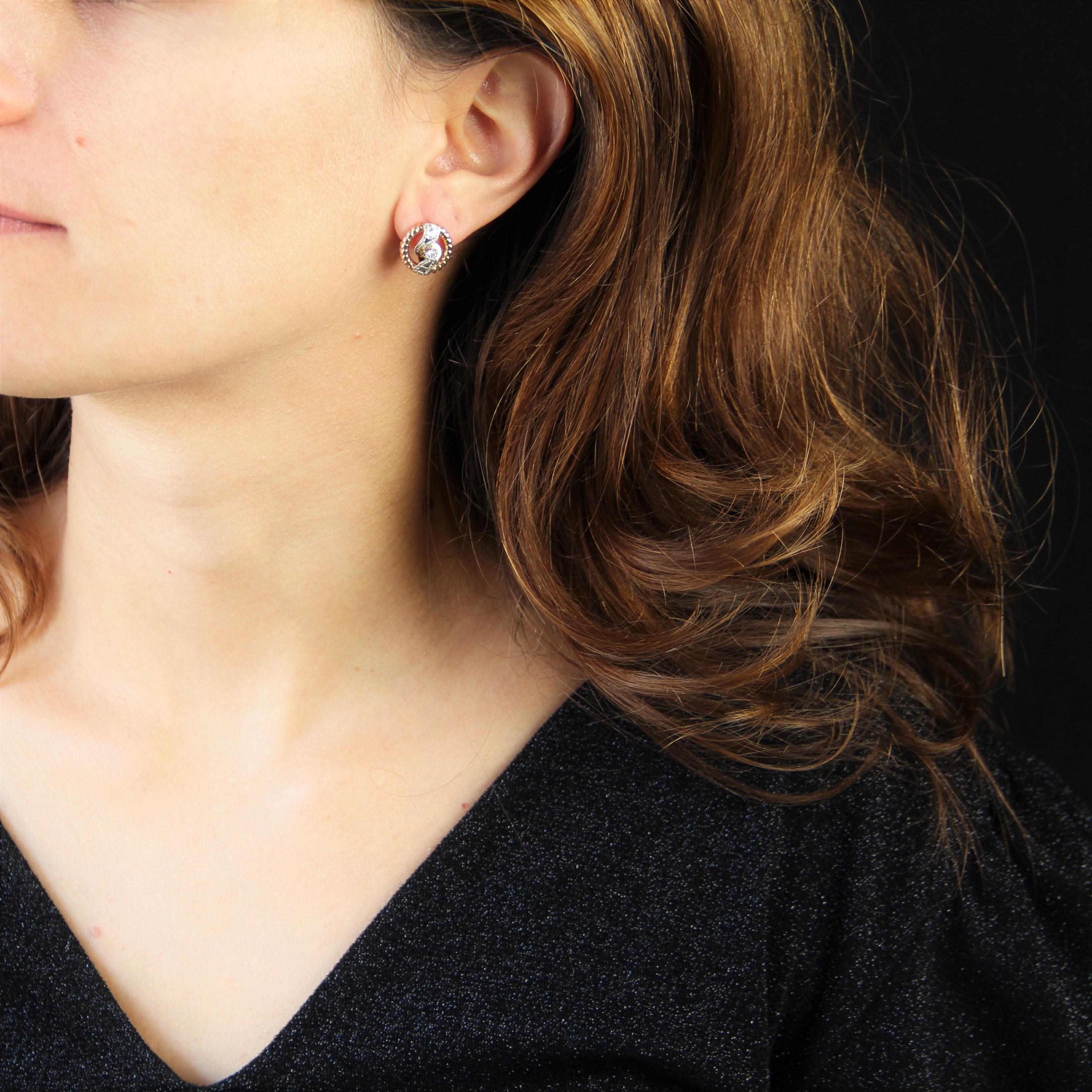 For pierced ears.
Earrings in 18 karat rose and white gold, eagle head hallmark.
Consisting of a circle of pearled rose gold, each retro earring is adorned with a white gold pattern chiseled with diamond points and holding a modern brilliant-cut