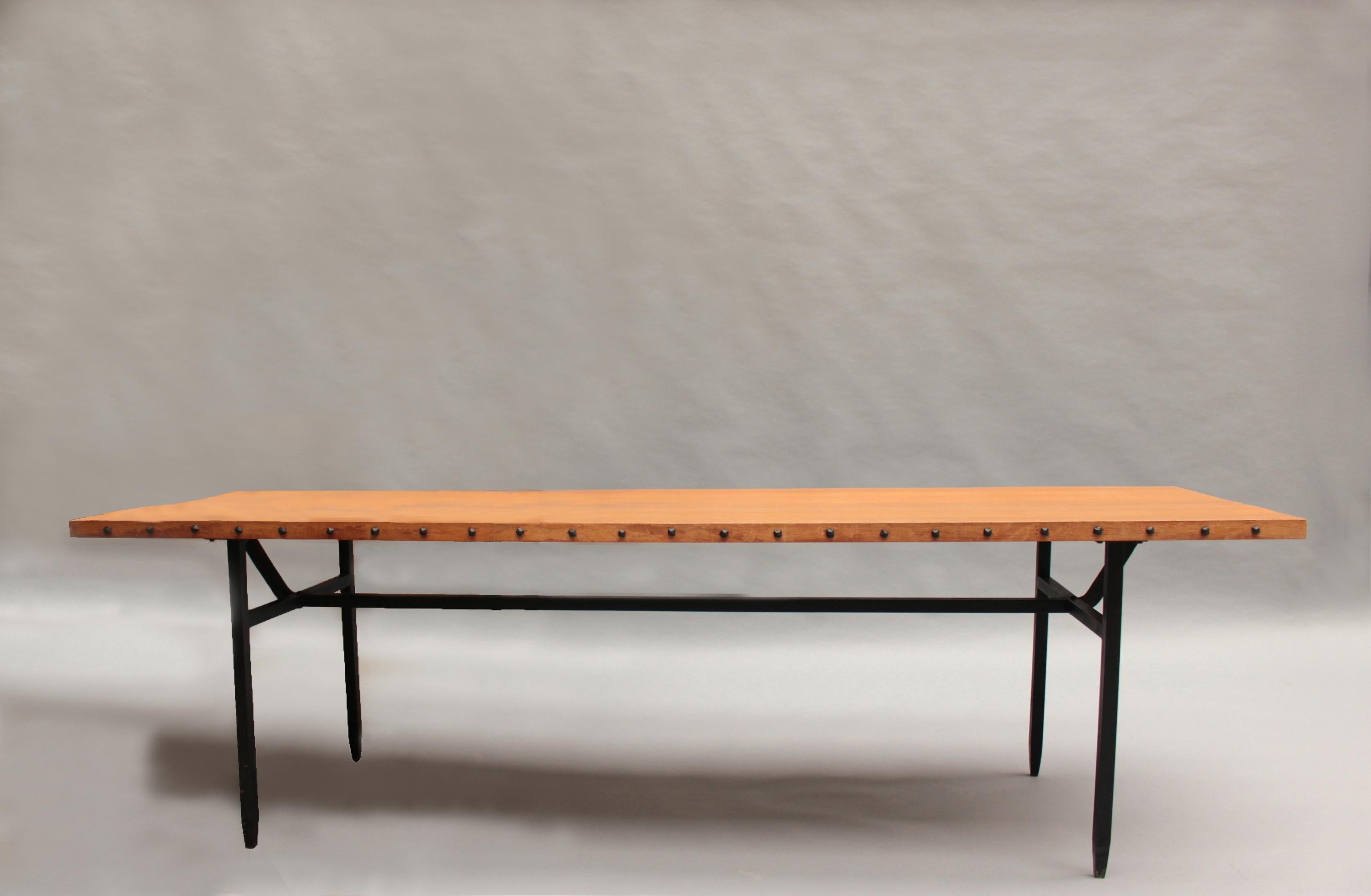 Jean Touret & the Artisans of Marolles - A fine mid-century rectangular dining table with a wrought iron base that supports a solid oak top adorned with wrought iron nails.