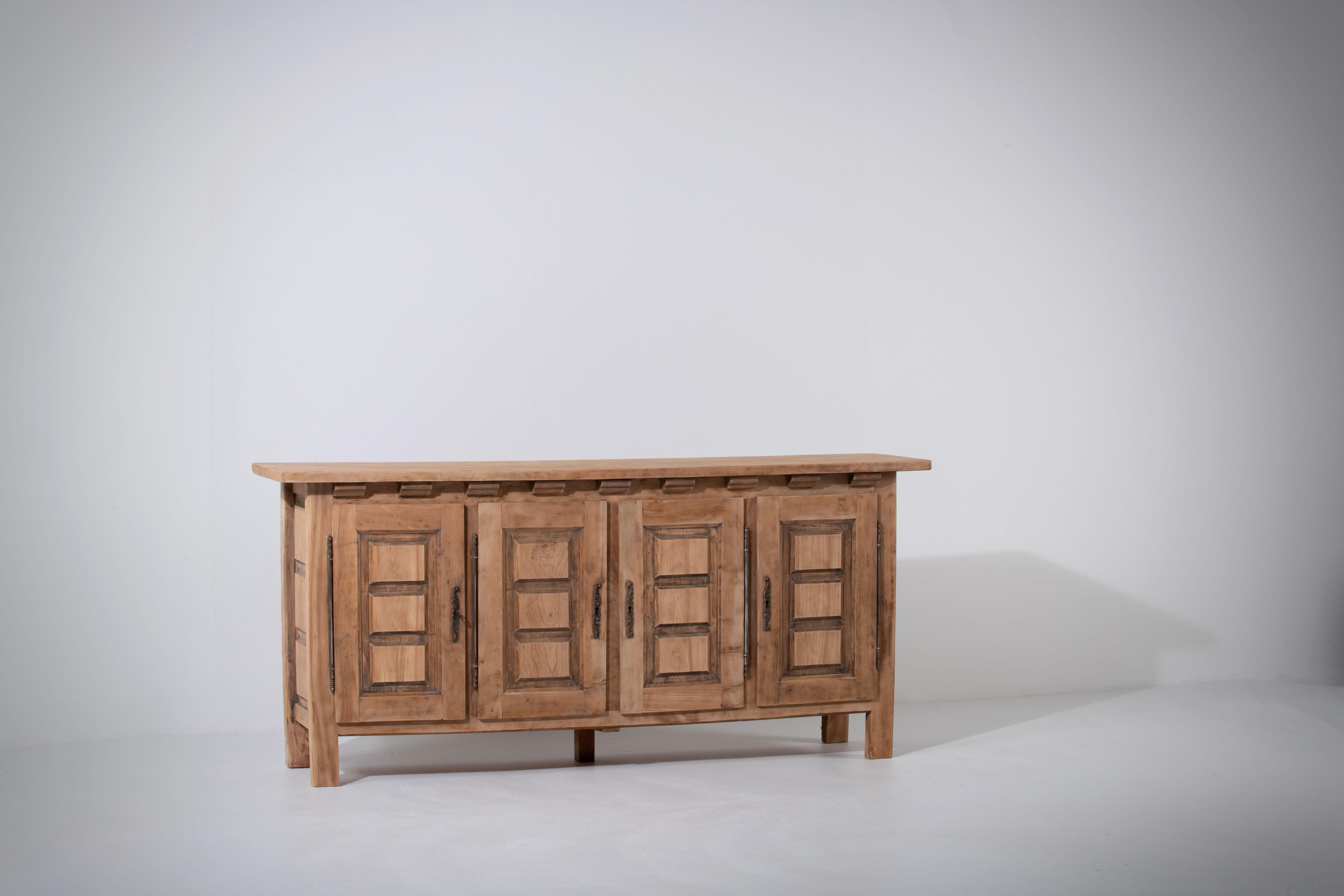 Presenting a noteworthy four-door sideboard, exuding an Alpine Chalet style, crafted from solid elm and discovered in the Maritime Alps. This unique cabinet, originating from the 1960s, harmoniously merges functionality with striking design, making