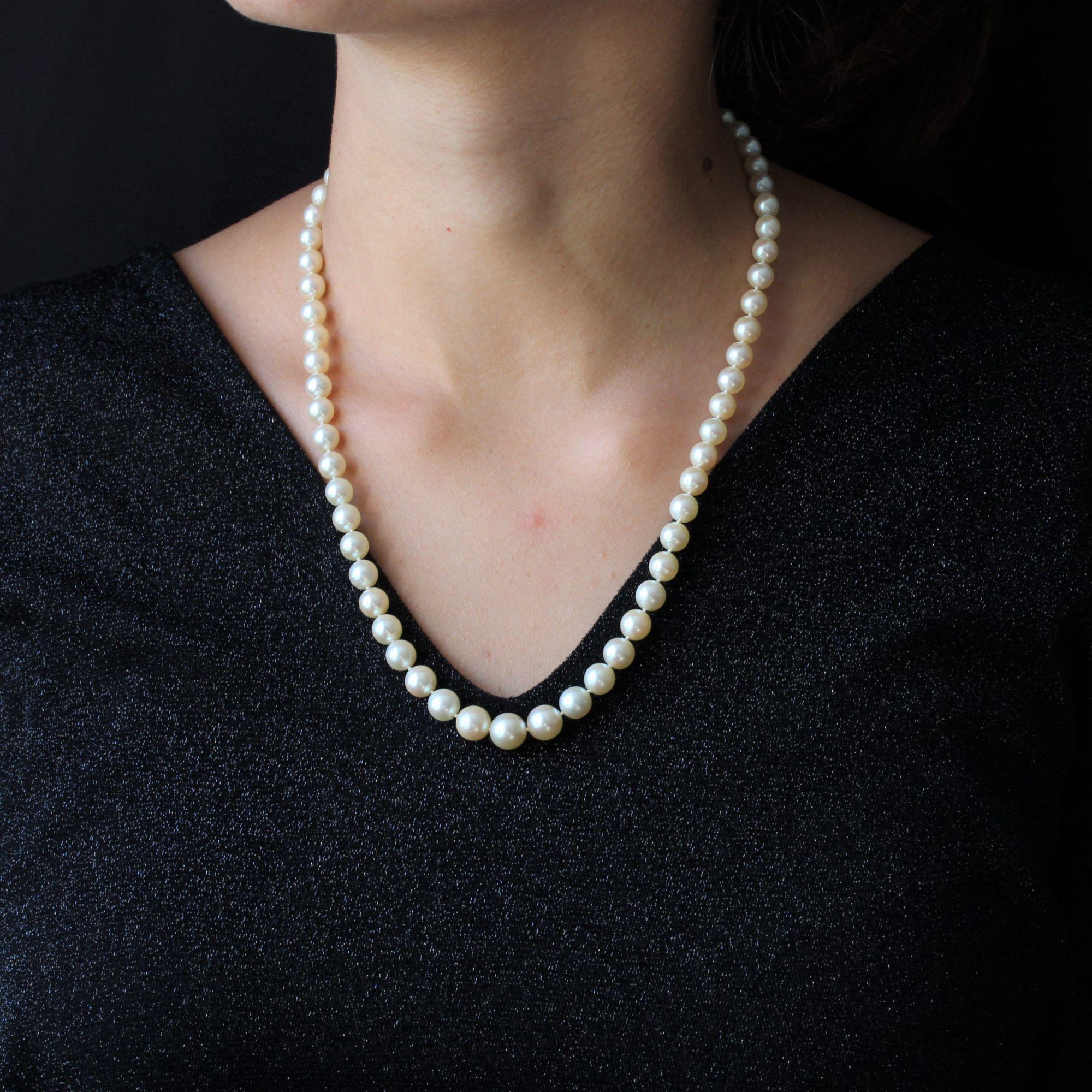 Necklace of cultured pearls falling with nuanced white orient. It presents a clasp in 18 karat yellow gold, eagle head hallmark, made of gold twists and set with 4 diamonds 8/8- cut and 3 round emeralds, the last one being on the push button.
The