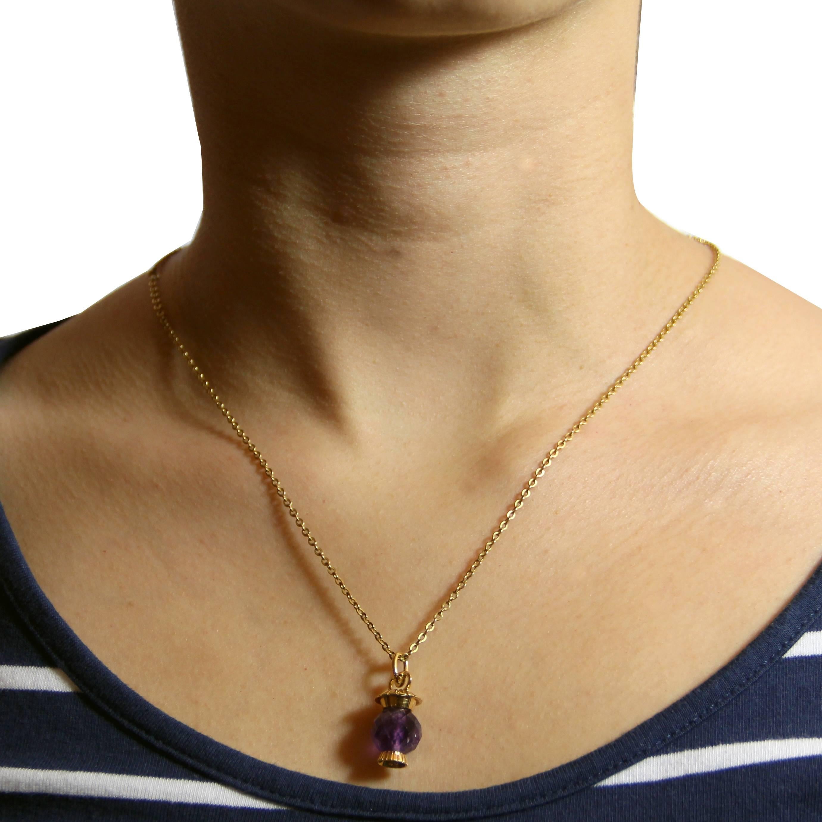 Pendant in 18 carats yellow gold, eagle's head hallmark.
This lovely retro pendant holds between two gold caps carved a faceted amethyst pearl giving it the shapes of a lantern. An oblong ring constitutes the bail.
Total height: 2.5 cm, width at the