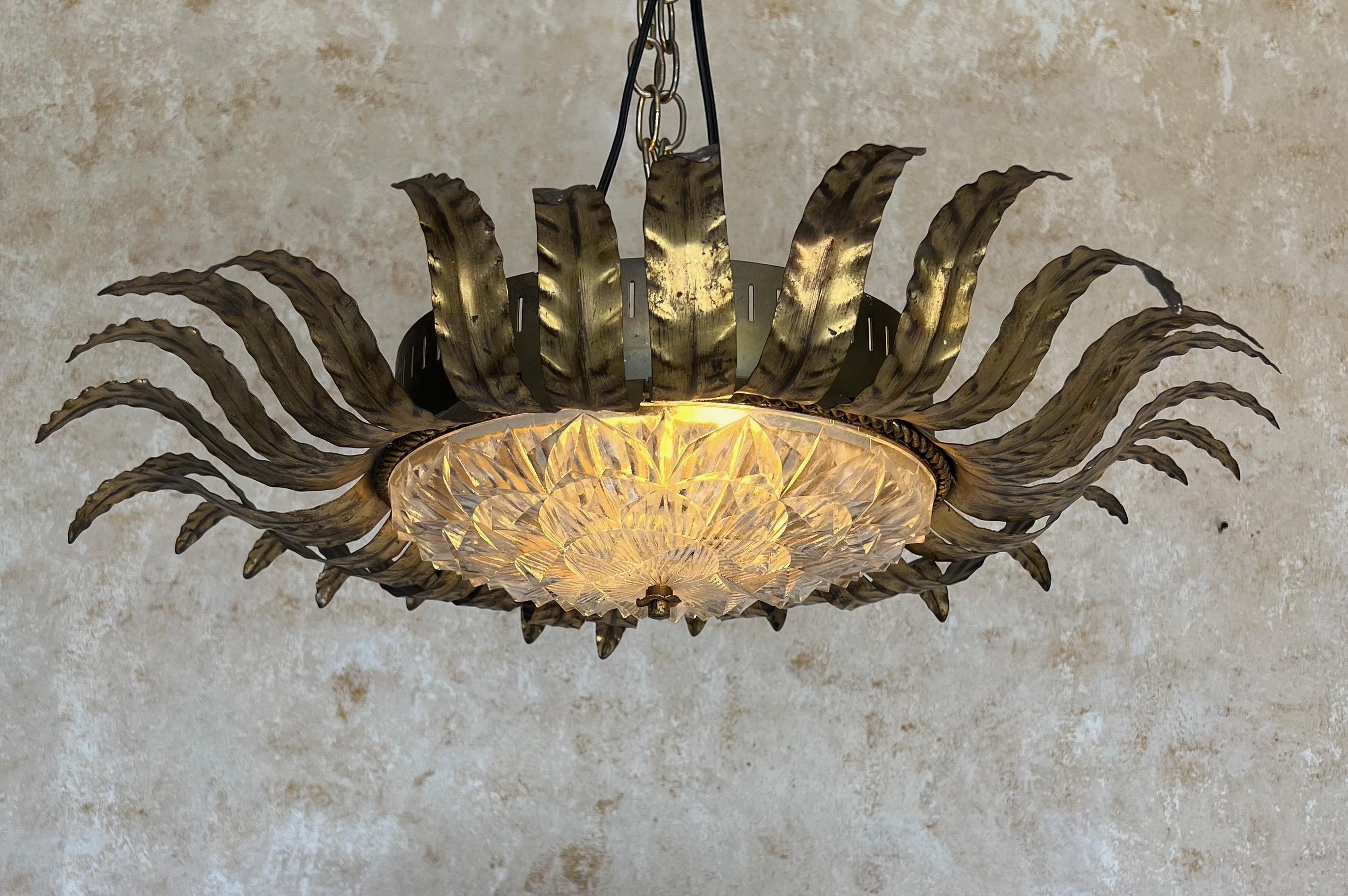 Ce magnifique plafonnier français du milieu du siècle présente un ensemble de feuilles en métal doré gracieusement incurvées entourant une bordure tressée qui soutient un bel abat-jour en verre moulé très détaillé qui irradie magnifiquement la