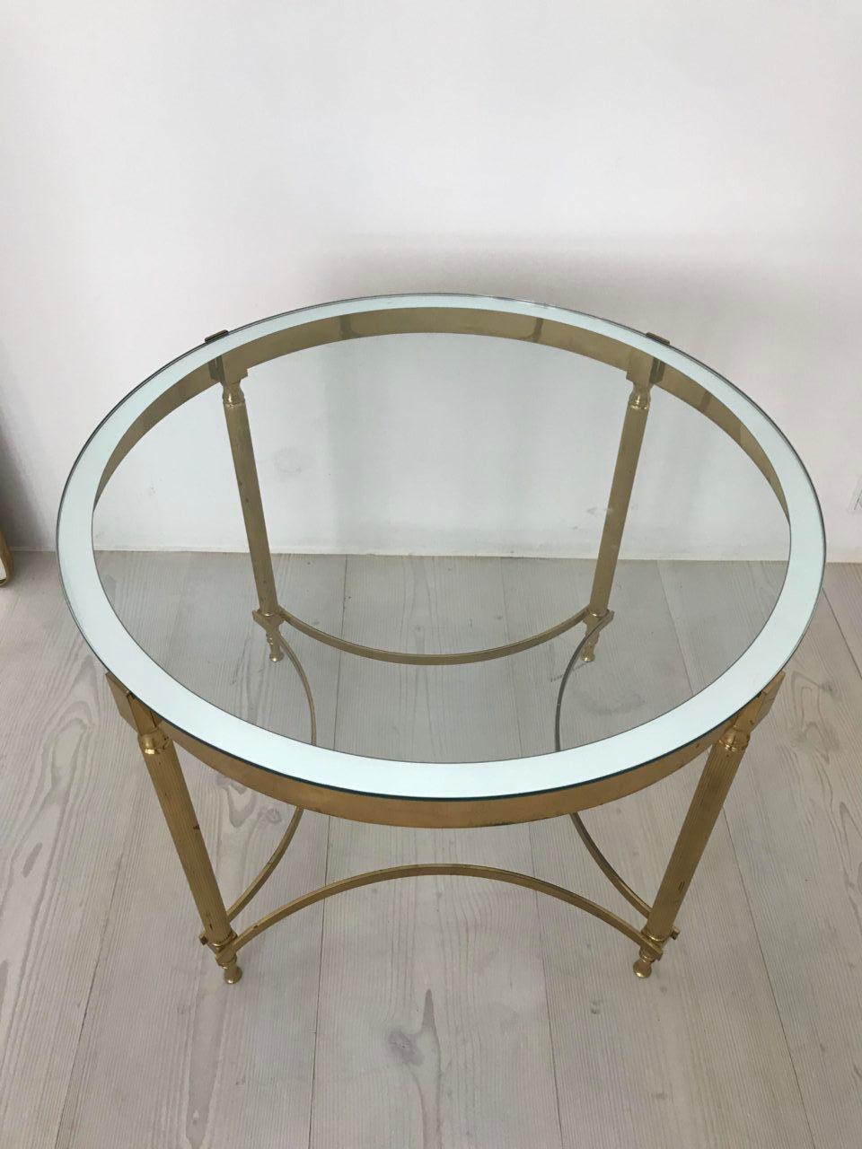 Sophisticated and beautiful tall circular coffee / lamp table. Made in brass, and from 1960s France. Elegantly made with a sleek brass frame holding a solid quality glass top with a mirrored edge giving a lovely finish, and standing on fluted