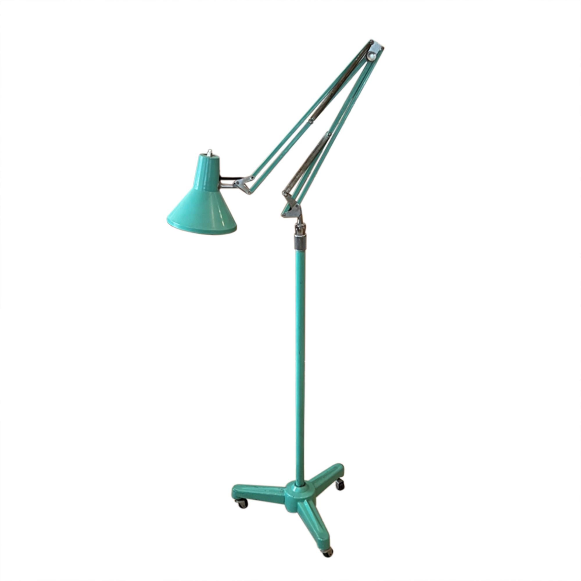 This French mid century floor lamp is fully adjustable and sits on a tripod stand with castors. 

The original light green - turquoise paint gives this light a cheerful character. We've had it rewired with black, rope twisted silk flex, the button