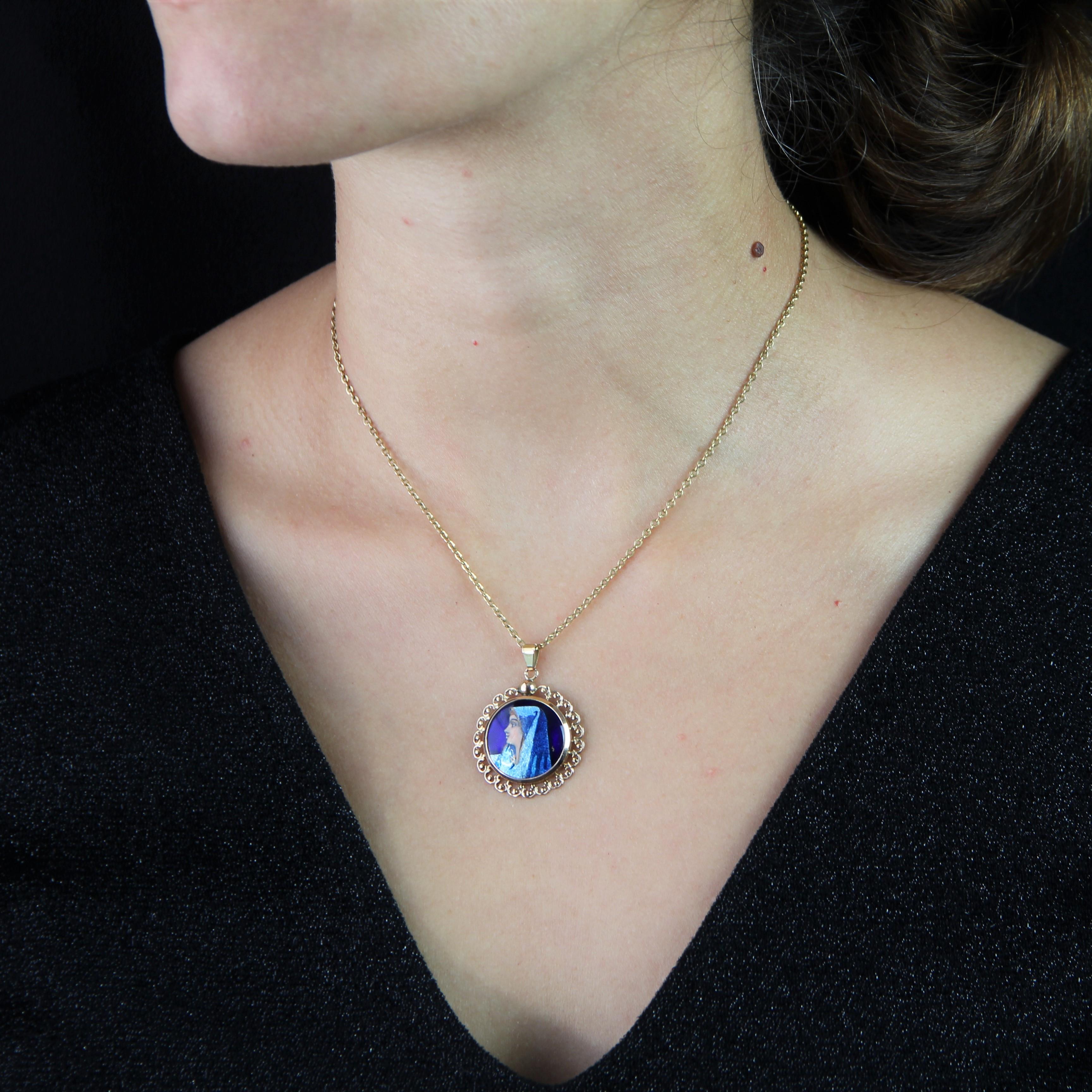 Pendant in 18 karat rose gold, eagle head hallmark.
Antique round pendant, it is composed of an enamel of Limoges representing a woman wearing a blue veil on a navy blue background. Its frame is decorated with arabesques and openworked.
Height : 3.5