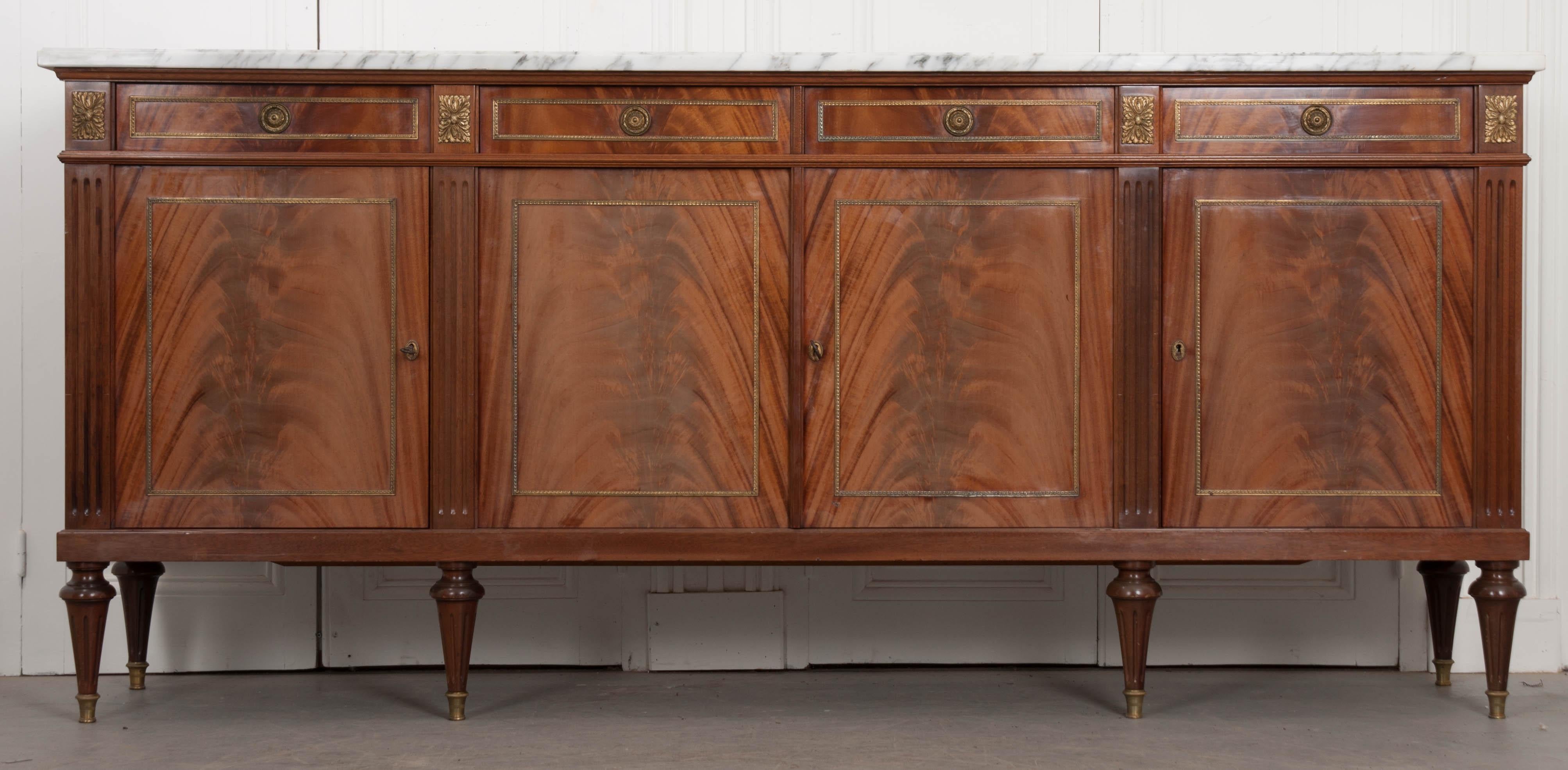 This large, marble-top enfilade was made in the 1960s, in France, and fashioned in the Louis XVI style. The white and gray marble top is in good antique condition and has neat corners that fit the body perfectly. Four drawers can be found in the