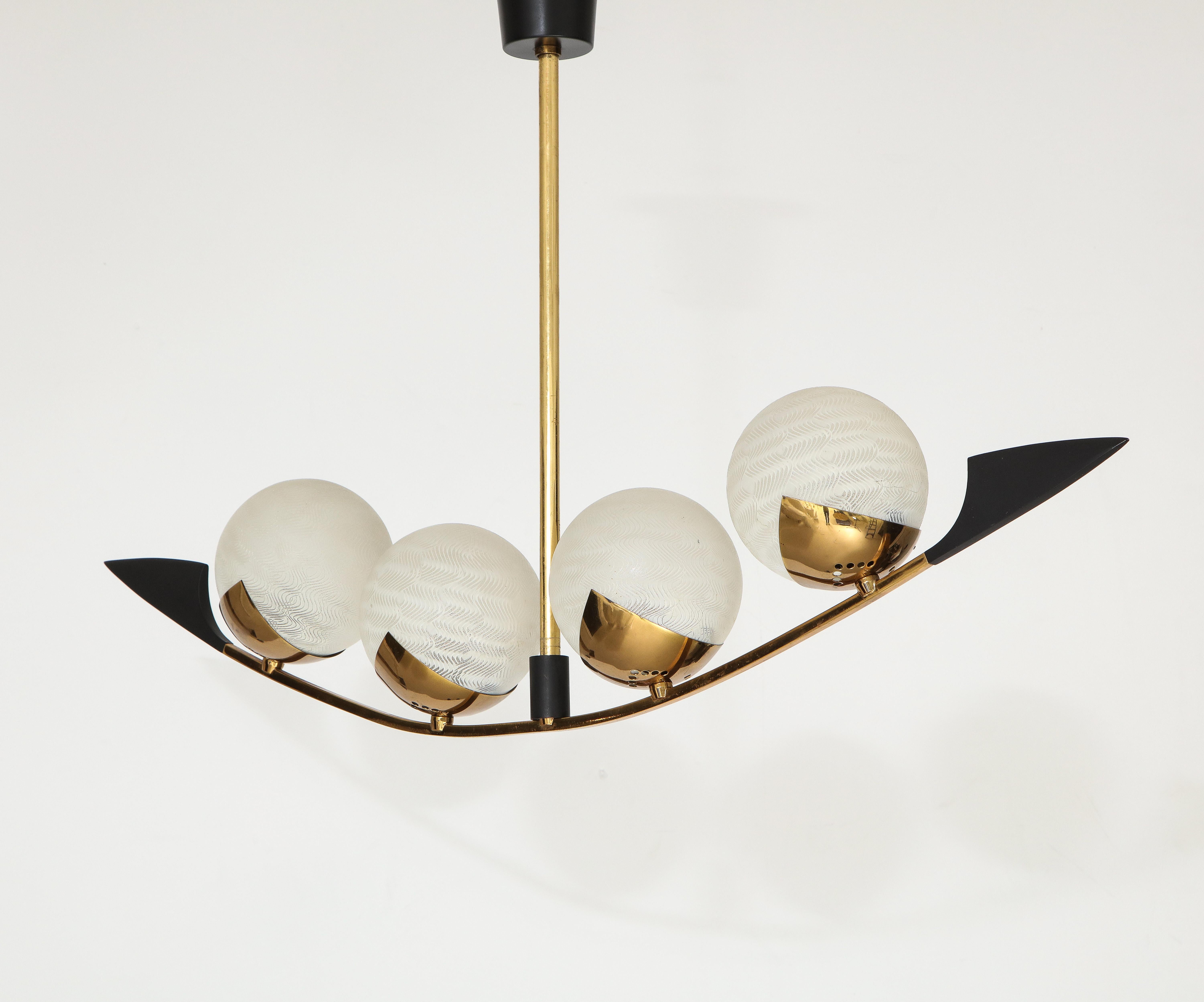 A wonderful French 1960s mid century 4 light chandelier done in polished brass and black enamel with decorative frosted globes by Lunel. Rewired. 4 candelabra 60 watt sockets.