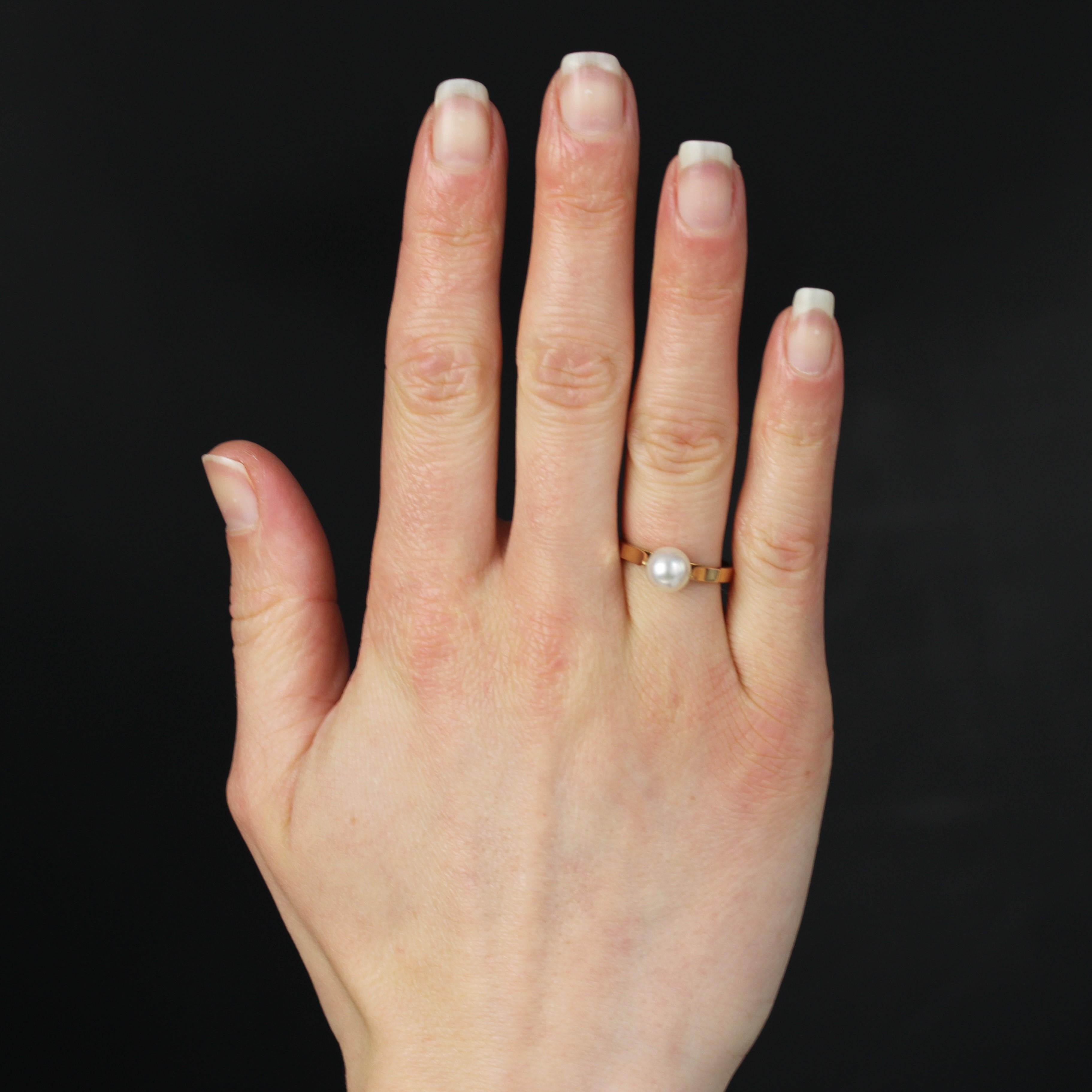 Bague en or jaune 18 carats, poinçon tête d'aigle.
Bague en or jaune présentant un solitaire en perle de culture orientale blanc nacré, surmonté de part et d'autre d'une lame d'or.
Diamètre de la perle : 7/7,5 mm environ.
Hauteur : 7,1 mm environ,