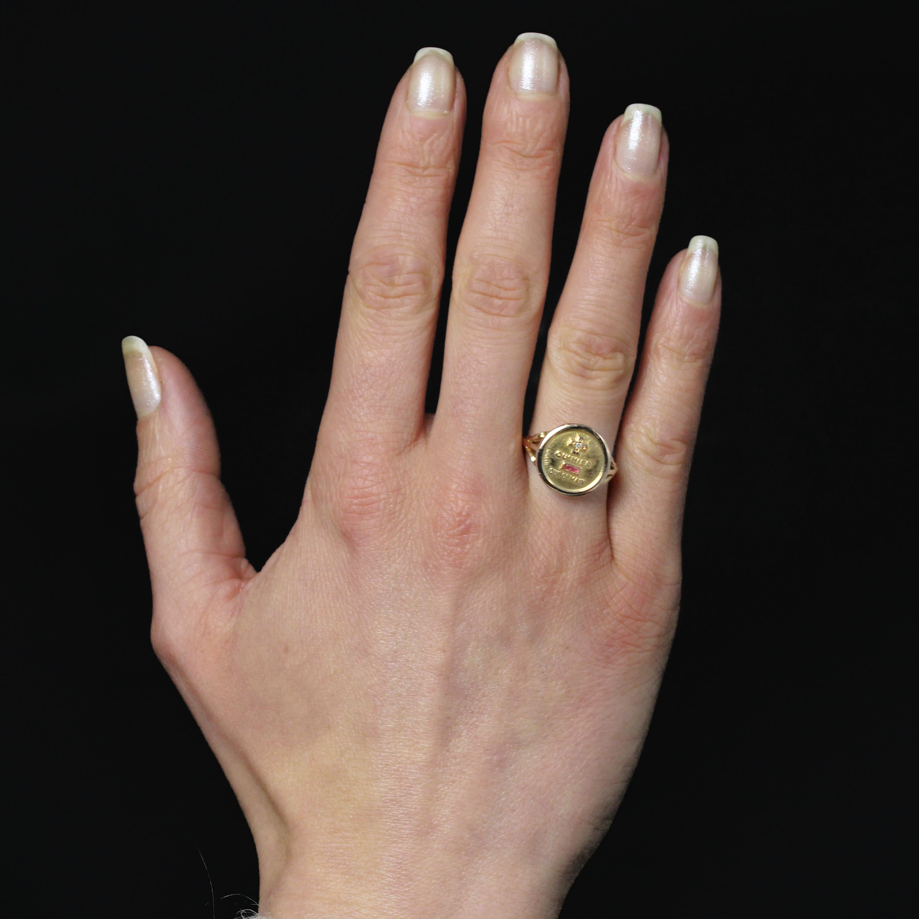Ring in 18 karat yellow gold, eagle head hallmark.
This ring by Augis features a round setting, adorned at the top with a medallion featuring the famous message “More than yesterday less than tomorrow”. A small diamond is set in the center of the