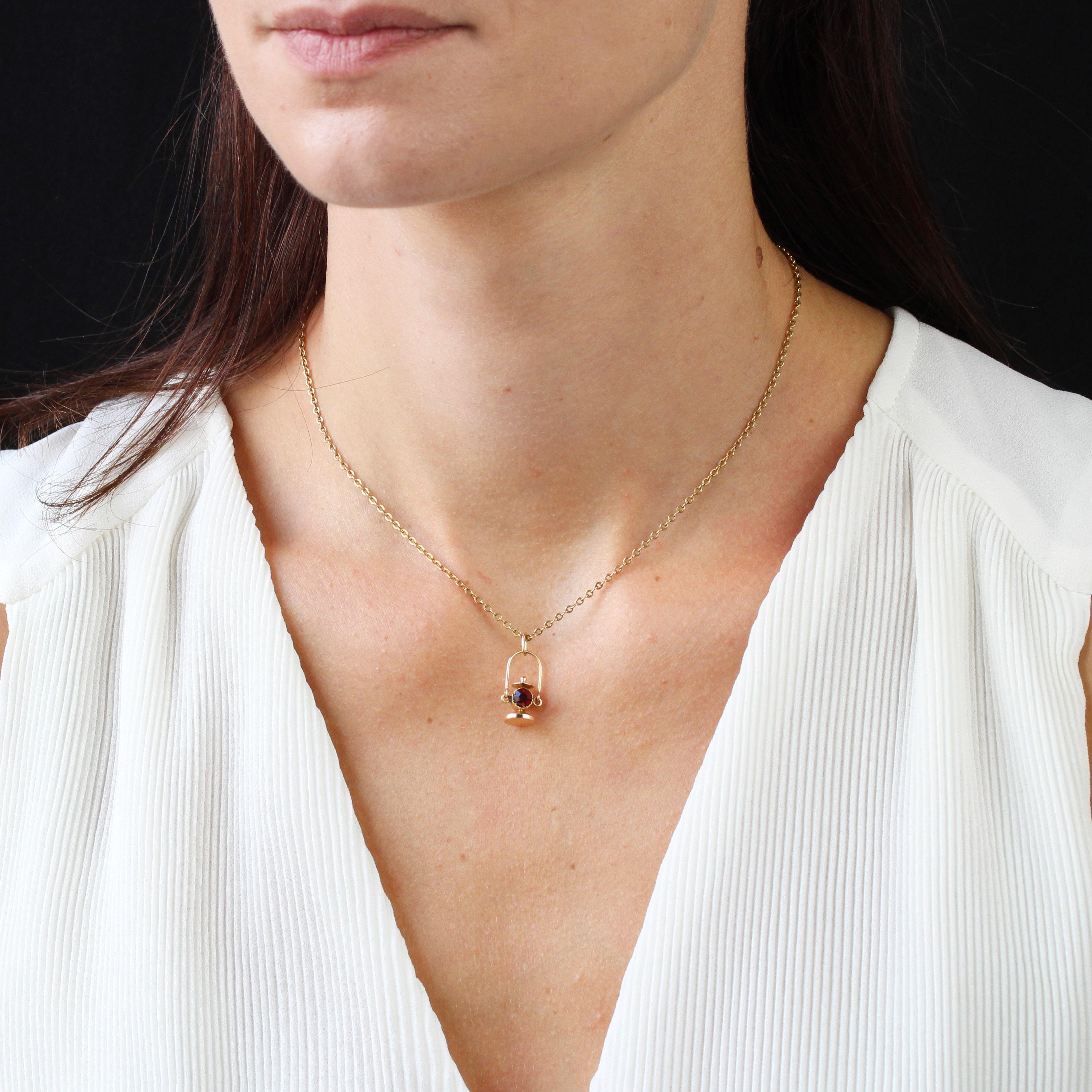 Pendant in 18 karat yellow gold.
This antique pendant depicts a lantern adorned with a round, close-set red stone in the center. The handle is movable and held in place by the clasp.
Pendant sold alone without its presentation chain.
Height : 2.3 cm