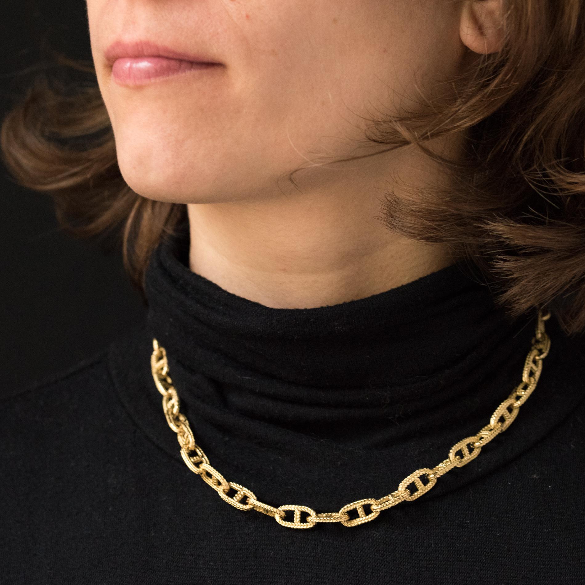 Necklace in 18 karats yellow gold, eagle's head hallmark.
This necklace is made of a massive chiseled navy mesh. The clasp is a ratchet ring with a safety 
