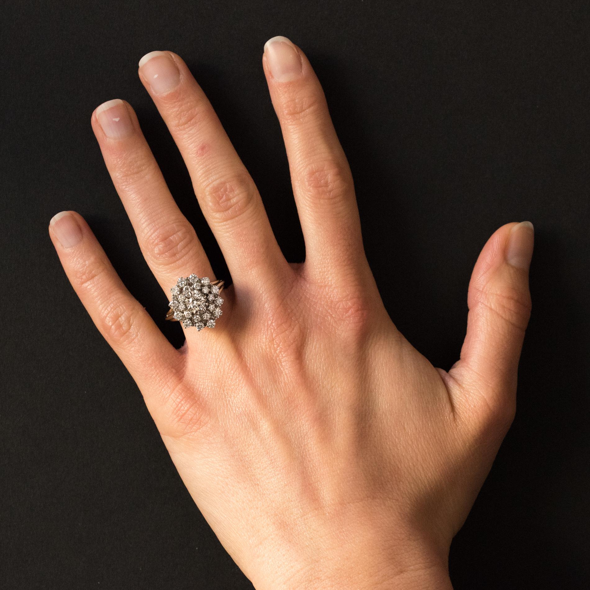 Ring in 18 karats white gold, eagle's head hallmark.
Retro ring, it is claws set in the center of a brilliant-cut diamond in a double entourage of brilliant-cut diamonds also claws set. The basket is openwork and made of golden thread such as the
