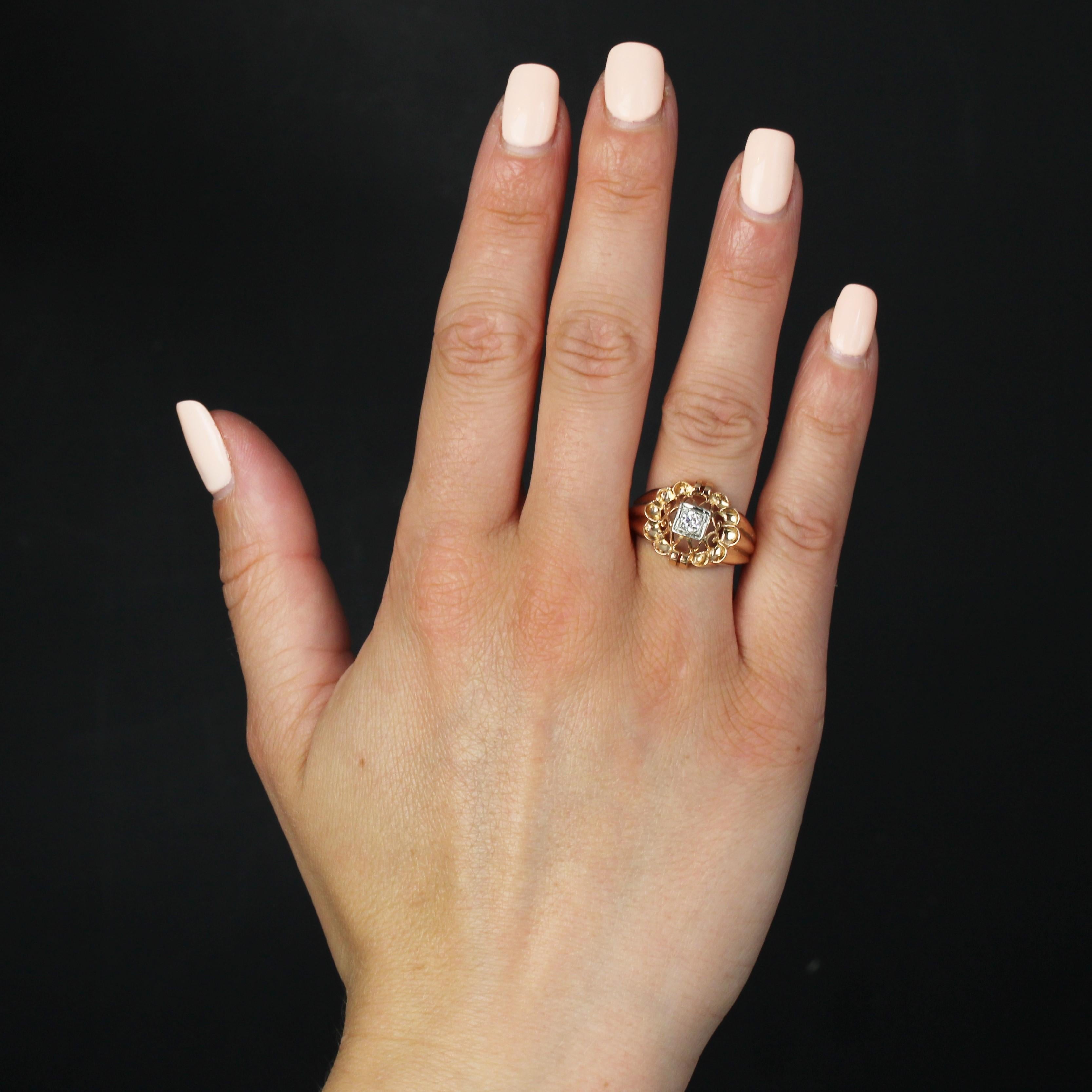 Ring in 18 karat rose gold, eagle head hallmark.
The band of this retro gold ring is gadrooned at the start and in the drop. The top is openworked with arabesque motifs and adorned in the center with a modern brilliant-cut diamond in a geometric