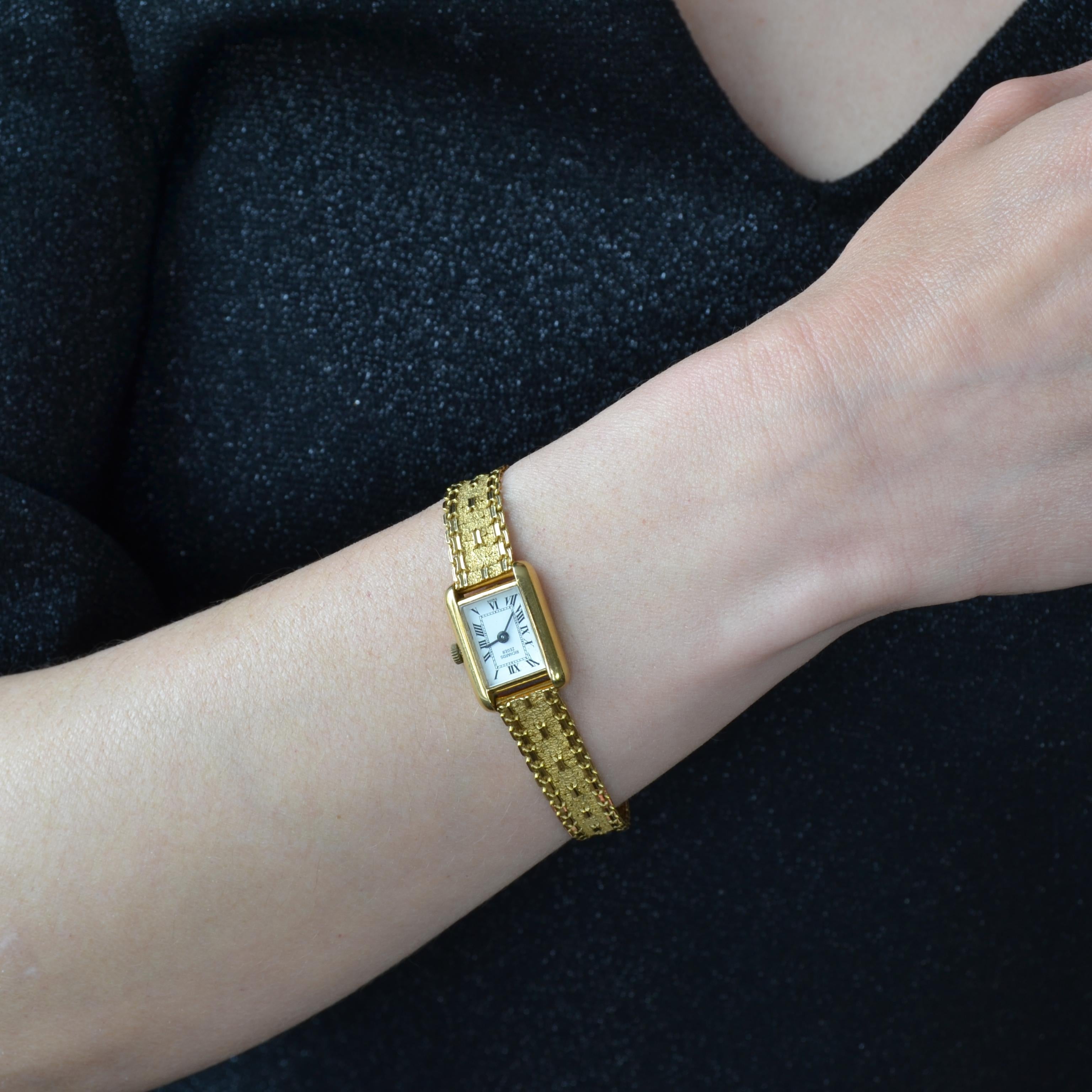 Montre de dame en or jaune 18 carats, poinçon tête d'aigle.
Boîtier rectangulaire, fond blanc, chiffres romains émaillés noirs, marqué 