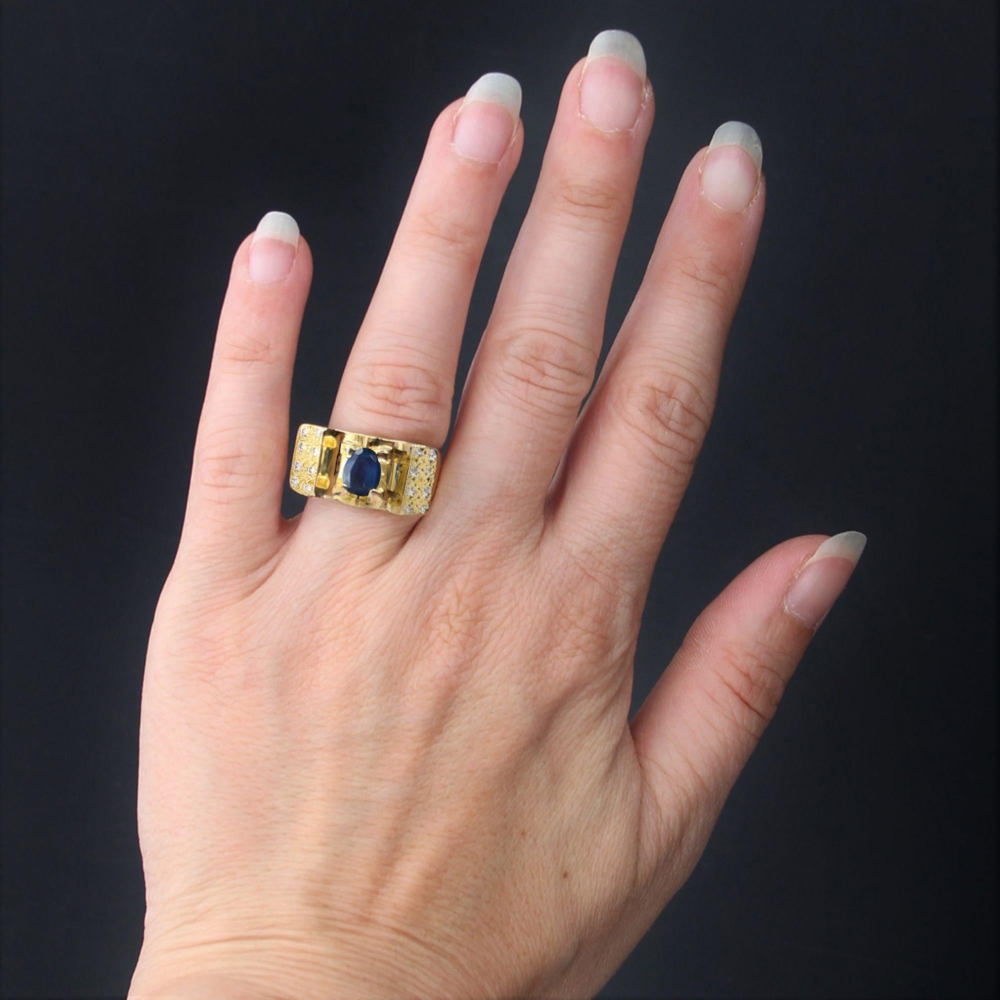 Ring aus 18 Karat Gelbgold, Adlerkopfpunze.
Dieser Saphirring ist von den Panzerringen der 1940er Jahre inspiriert. Er hat die Form einer Brücke und ist mit 4 großen Klauen eines ovalen, facettierten Saphirs besetzt, die auf beiden Seiten von 8