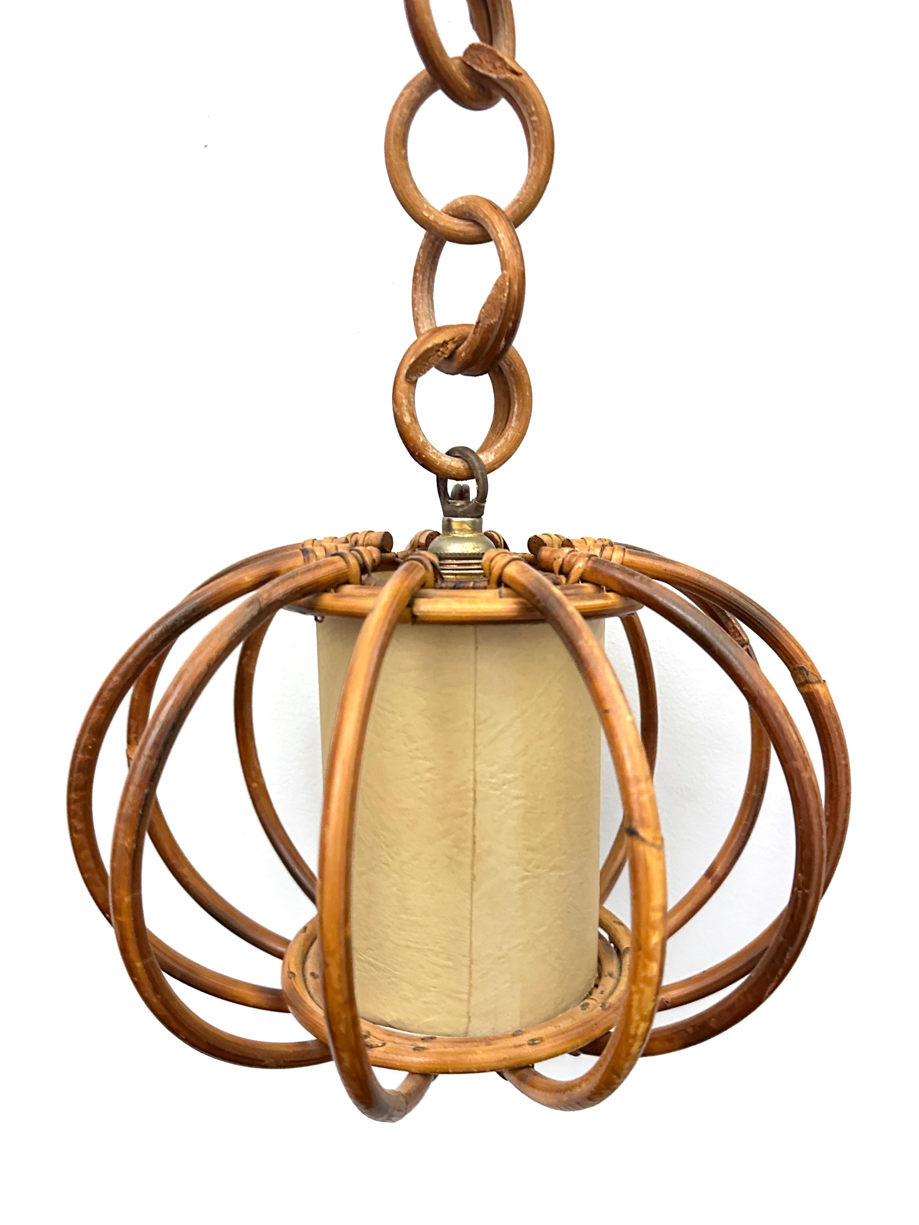 Bamboo and rattan french pendant lamp. Mid-century round piece with an interior parchment paper shade with a sort of linen texture. The interior shade is surrounded by a separate, round, rattan encasement. Beautiful hand made piece with wood vendind