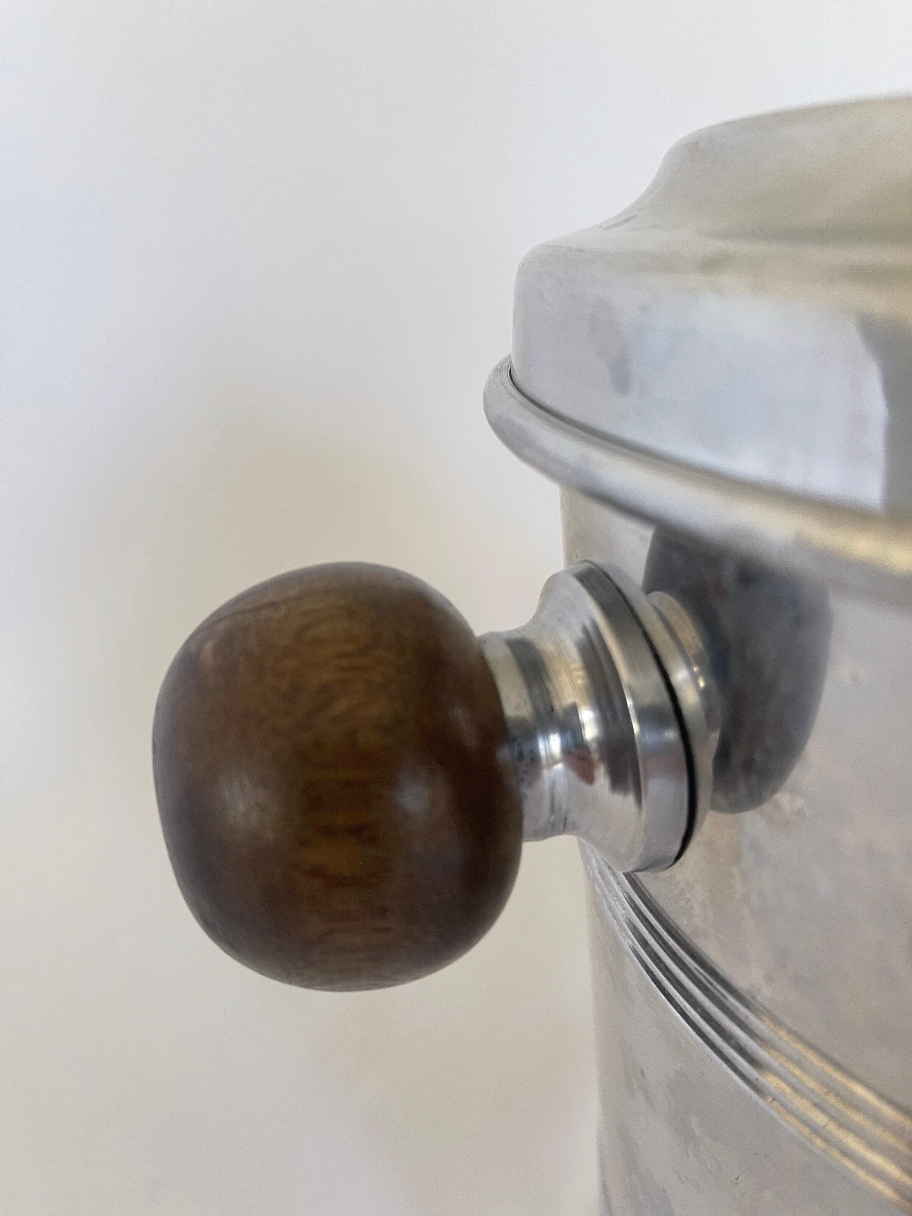 French 1970's circular aluminum ice bucket with covered top, adorned with walnut sphere and two walnut sphere handles.
Measurements with lid : 11